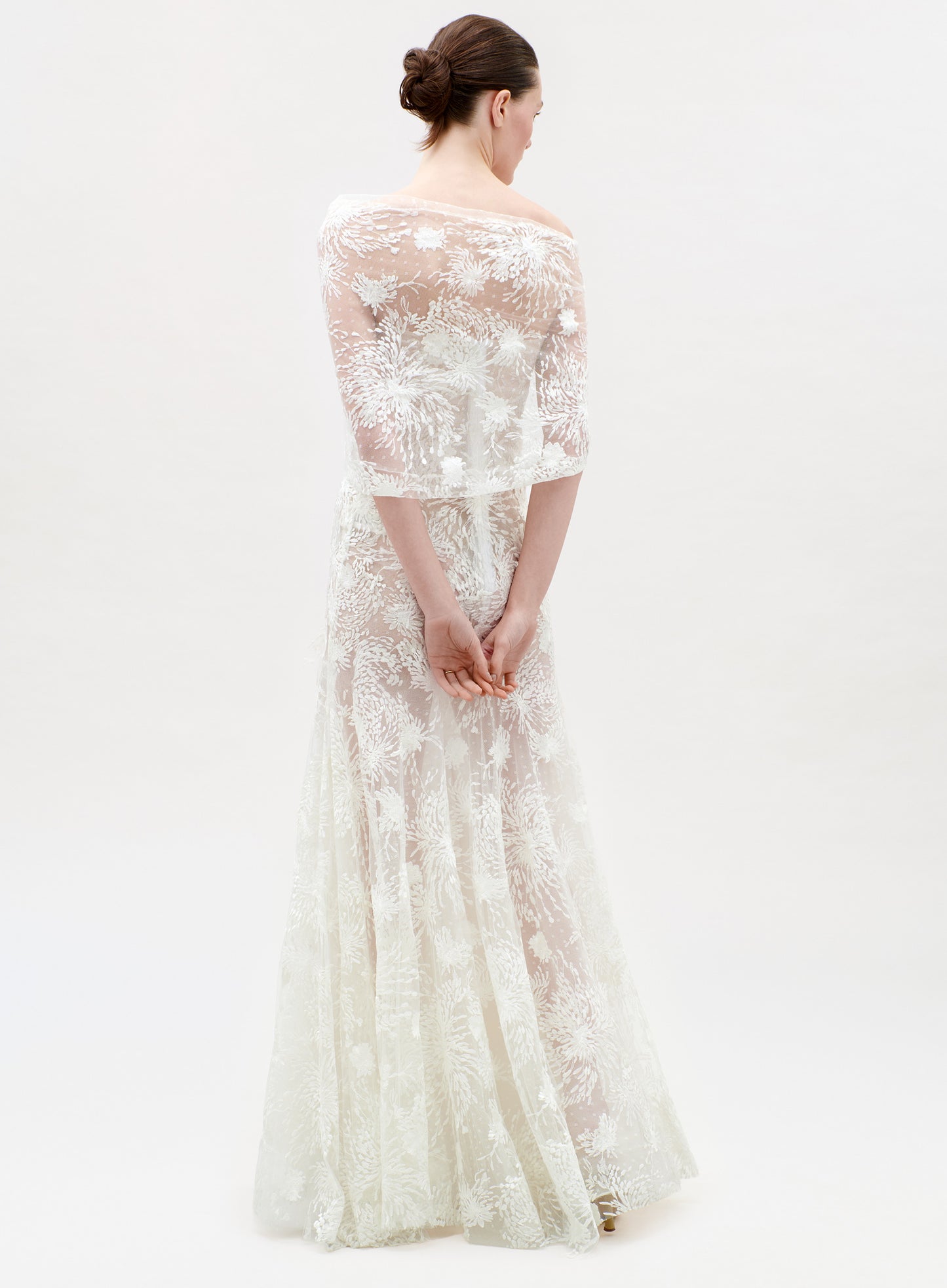 Woman wearing a white lace dress on a white background