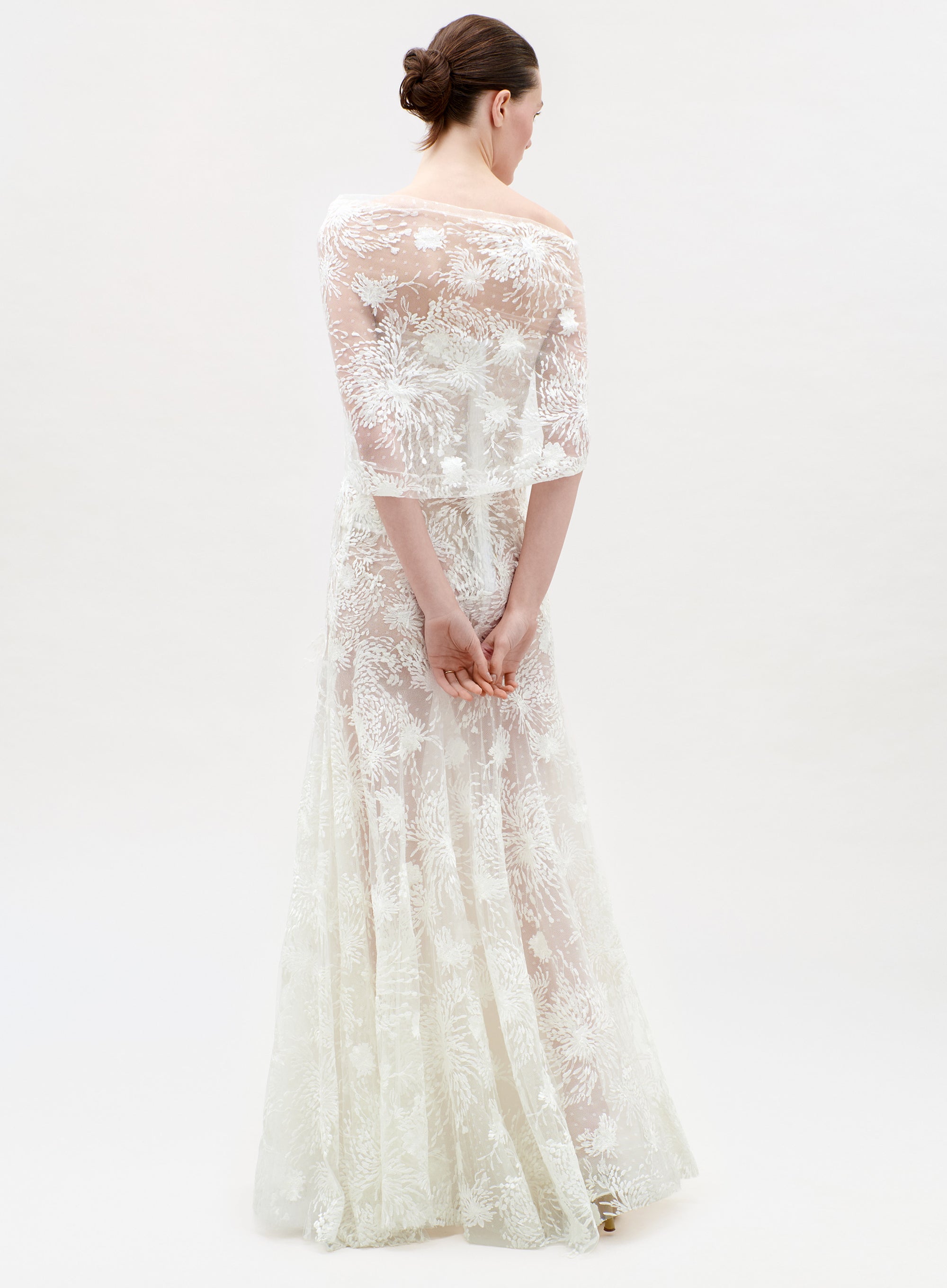 Woman wearing a white lace dress on a white background