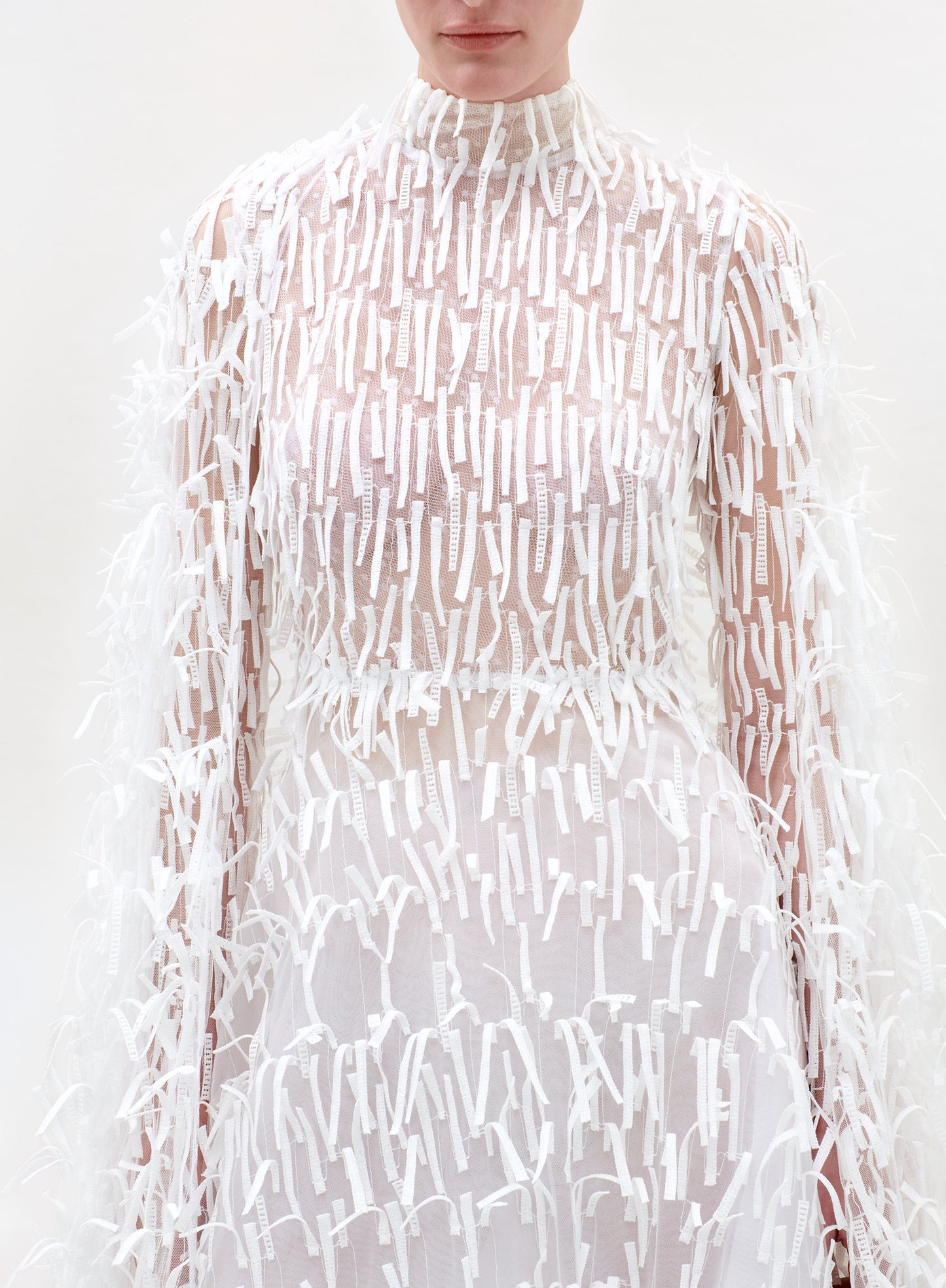Sheer white dress with a subtle pattern on a white background