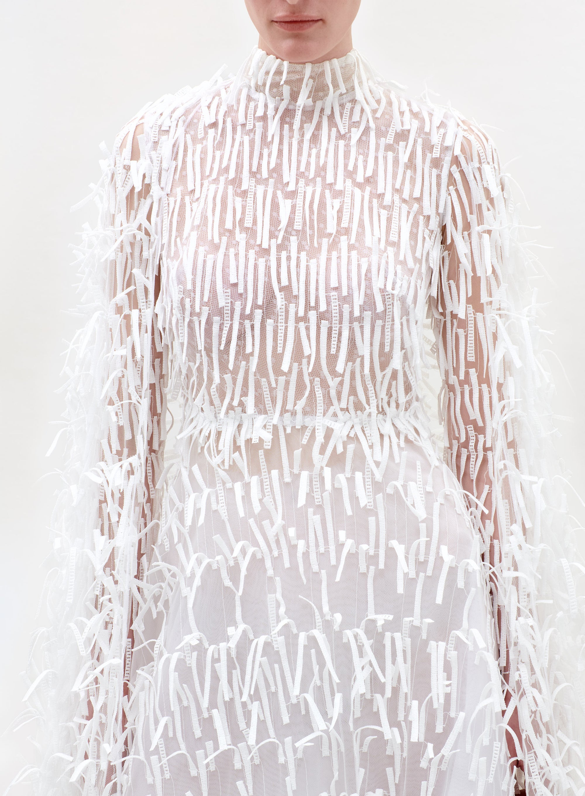 Sheer white dress with a subtle pattern on a white background