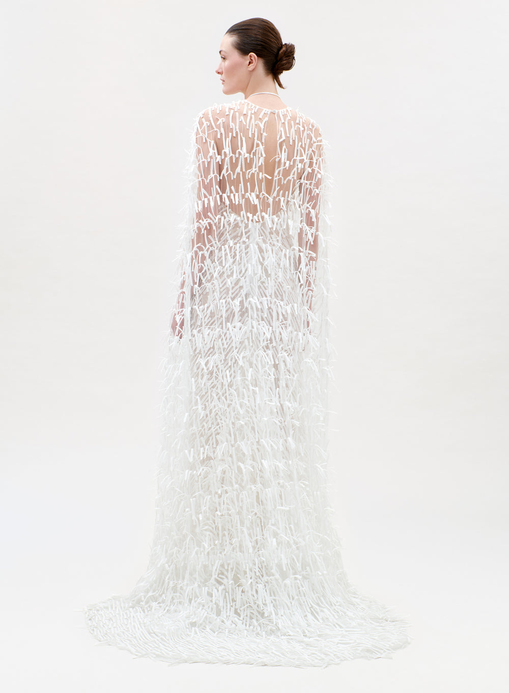 Woman wearing a white lace dress on a plain background