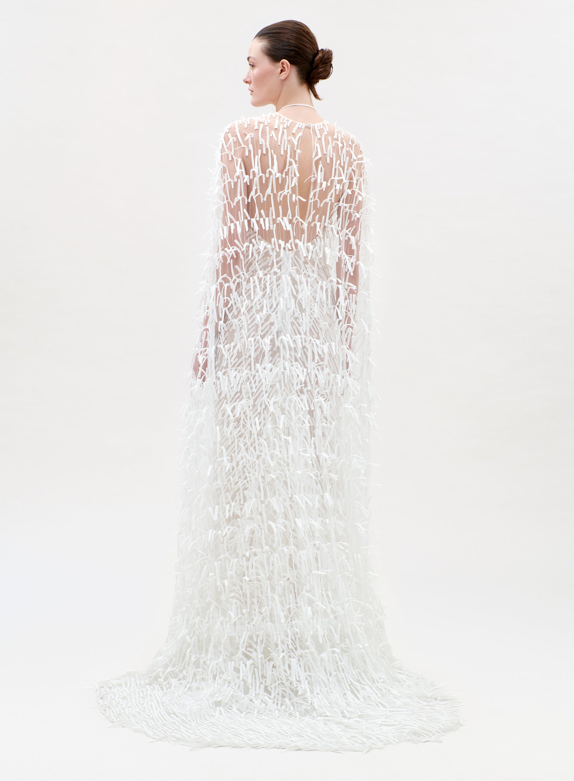 Woman wearing a white lace dress on a plain background