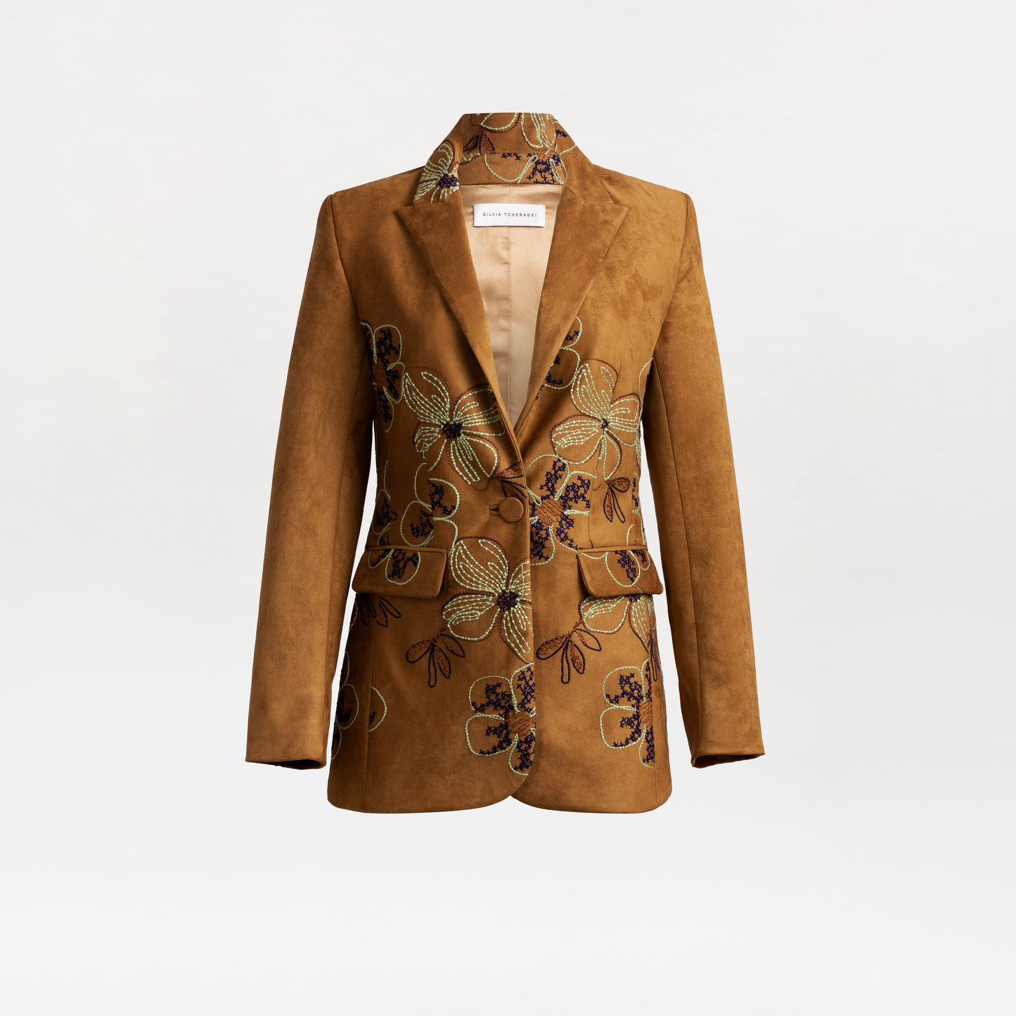 The Rebeca Jacket is a brown suede blazer with a notched collar, large lapels, and intricate green, purple, and beige floral embroidery, displayed against a plain light background.