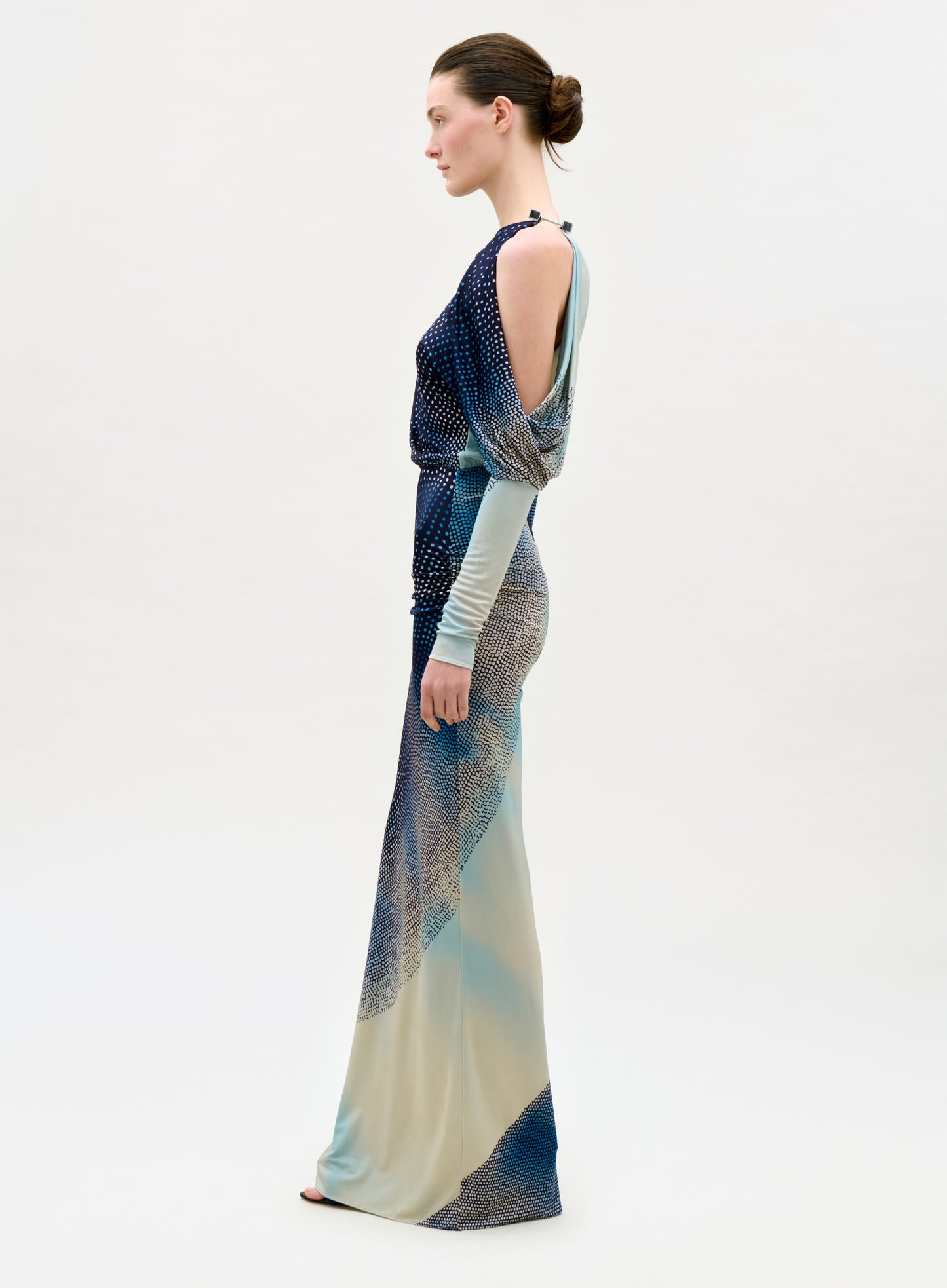 Woman wearing a long, patterned dress on a white background