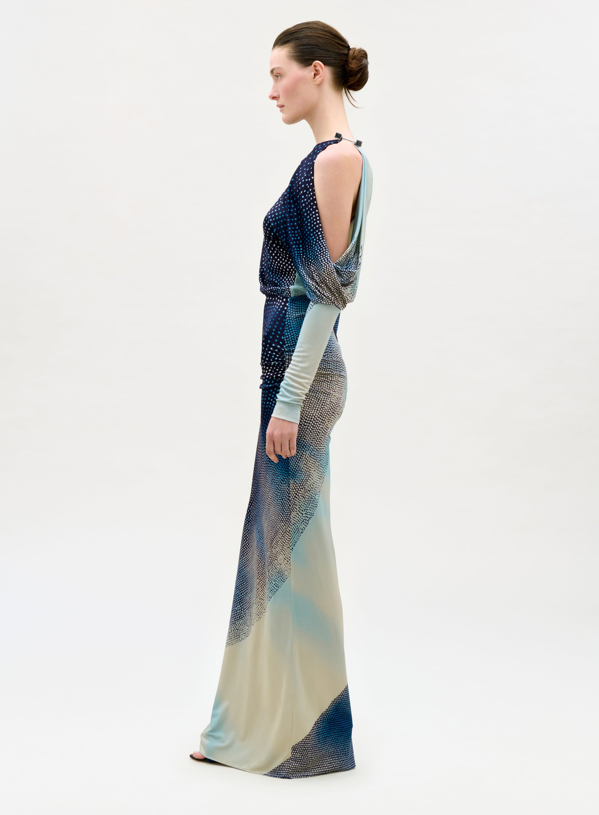 Woman wearing a long, patterned dress on a white background