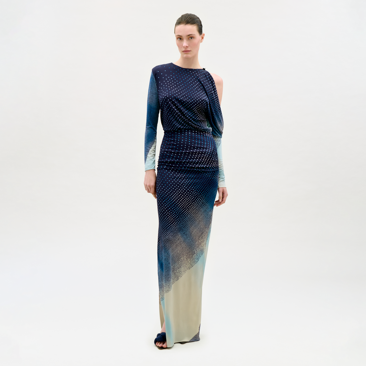 Woman wearing a long, patterned dress on a white background