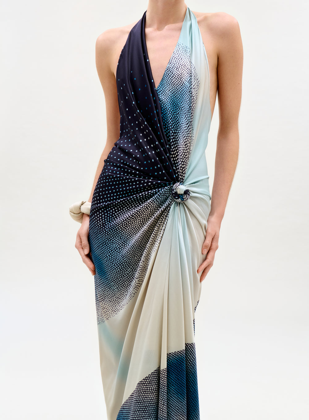 Woman wearing a gradient dress with blue and white colors on a plain background