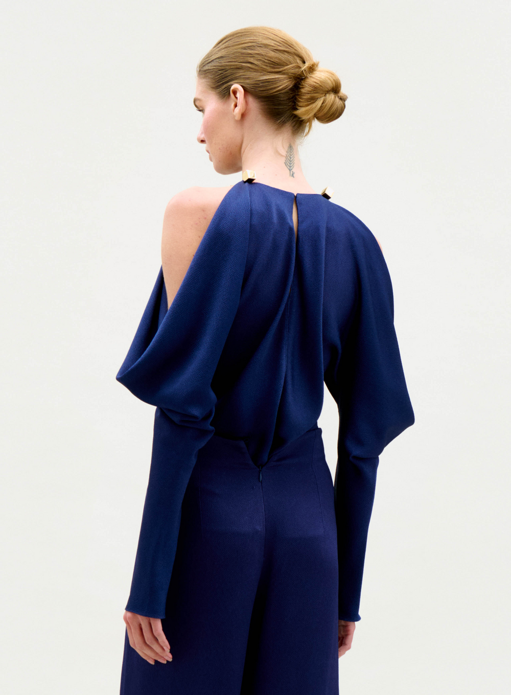Woman wearing a blue outfit with a plain background
