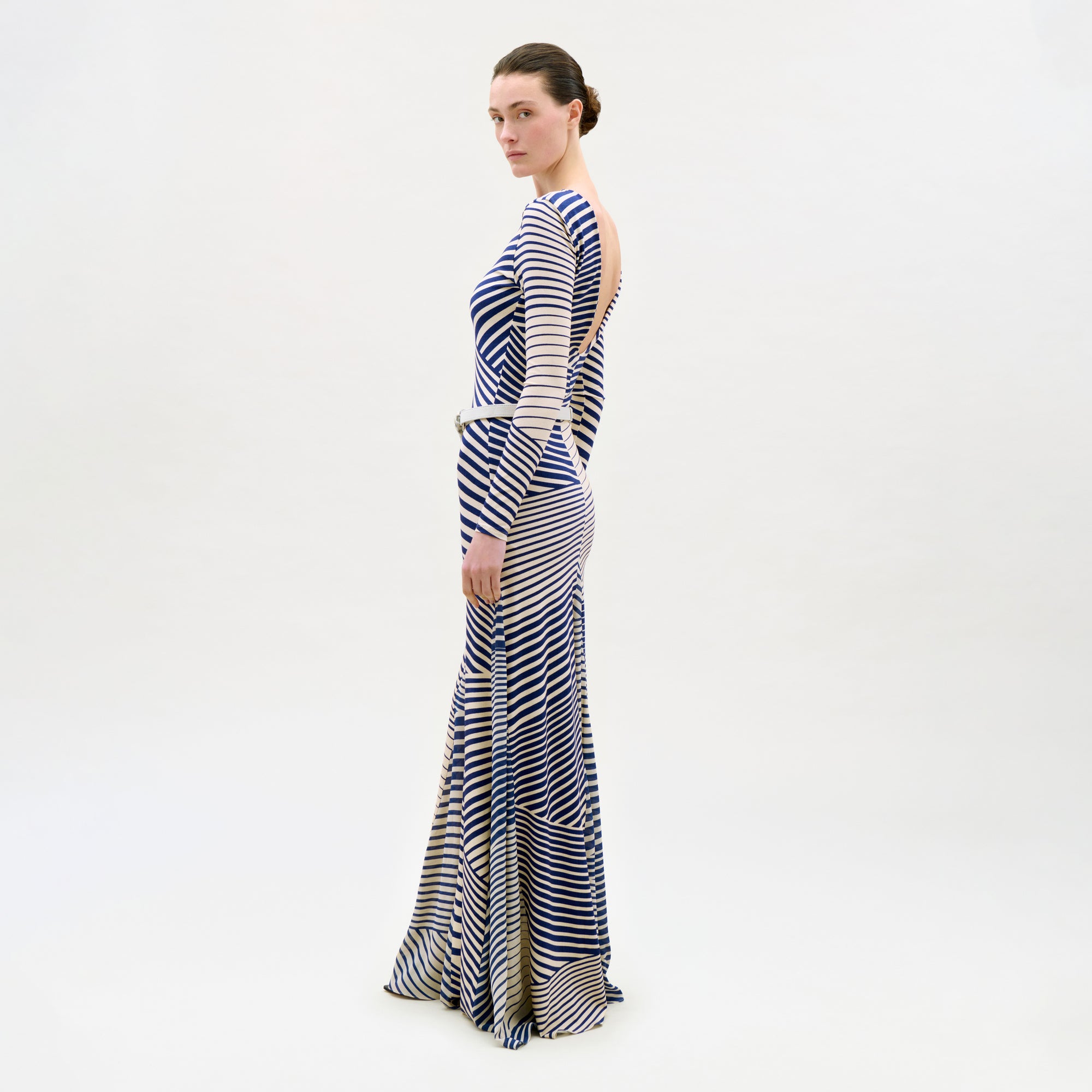 Woman wearing a long, striped dress on a white background