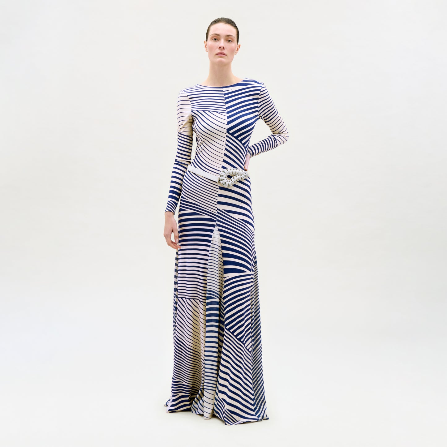 Woman wearing a long, patterned dress on a white background