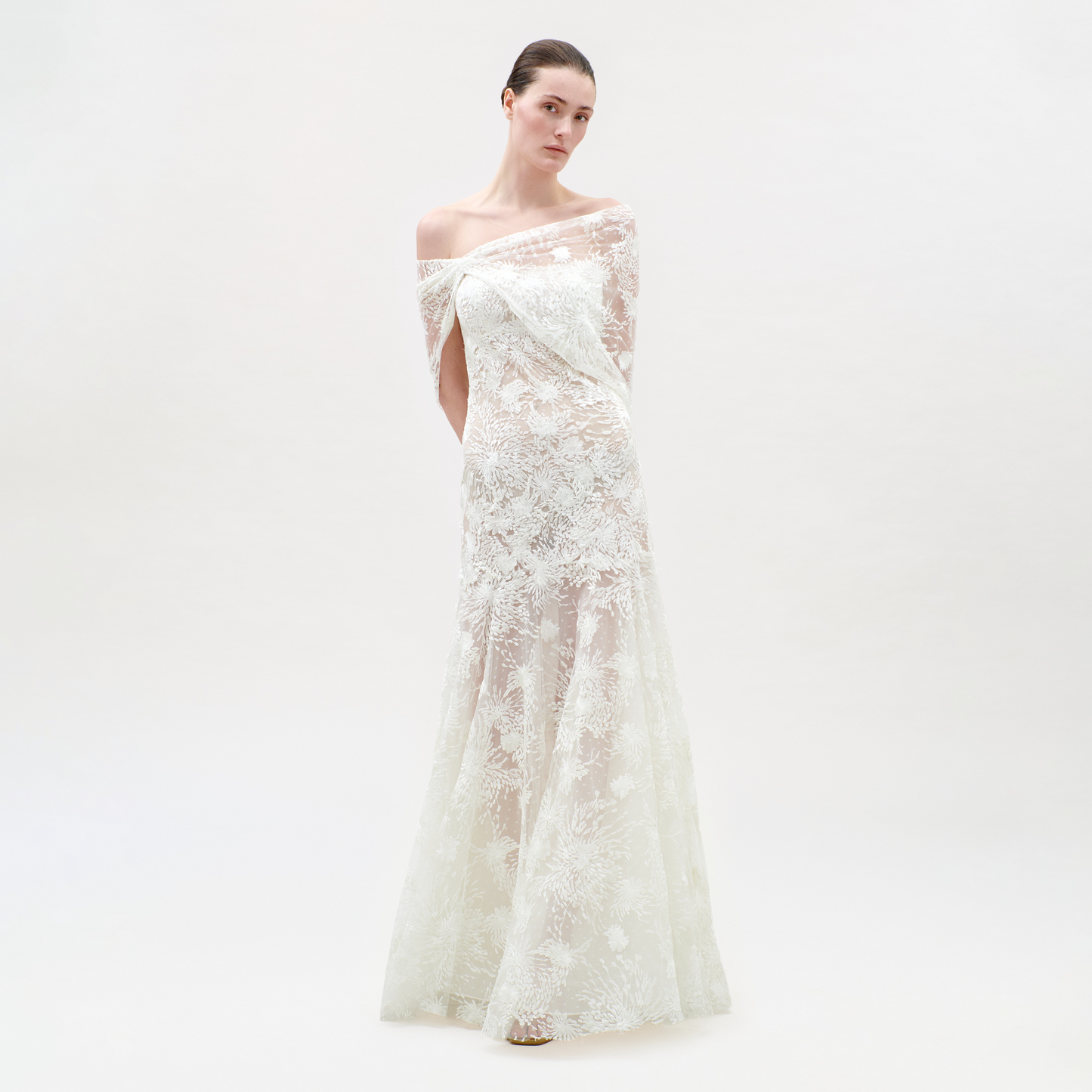Woman wearing a white lace dress on a plain background