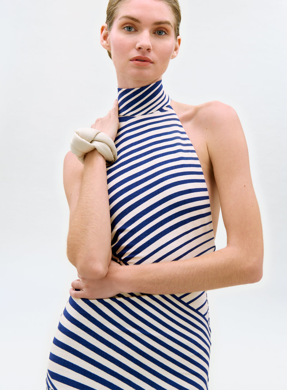 Woman wearing a blue and white striped dress against a plain background