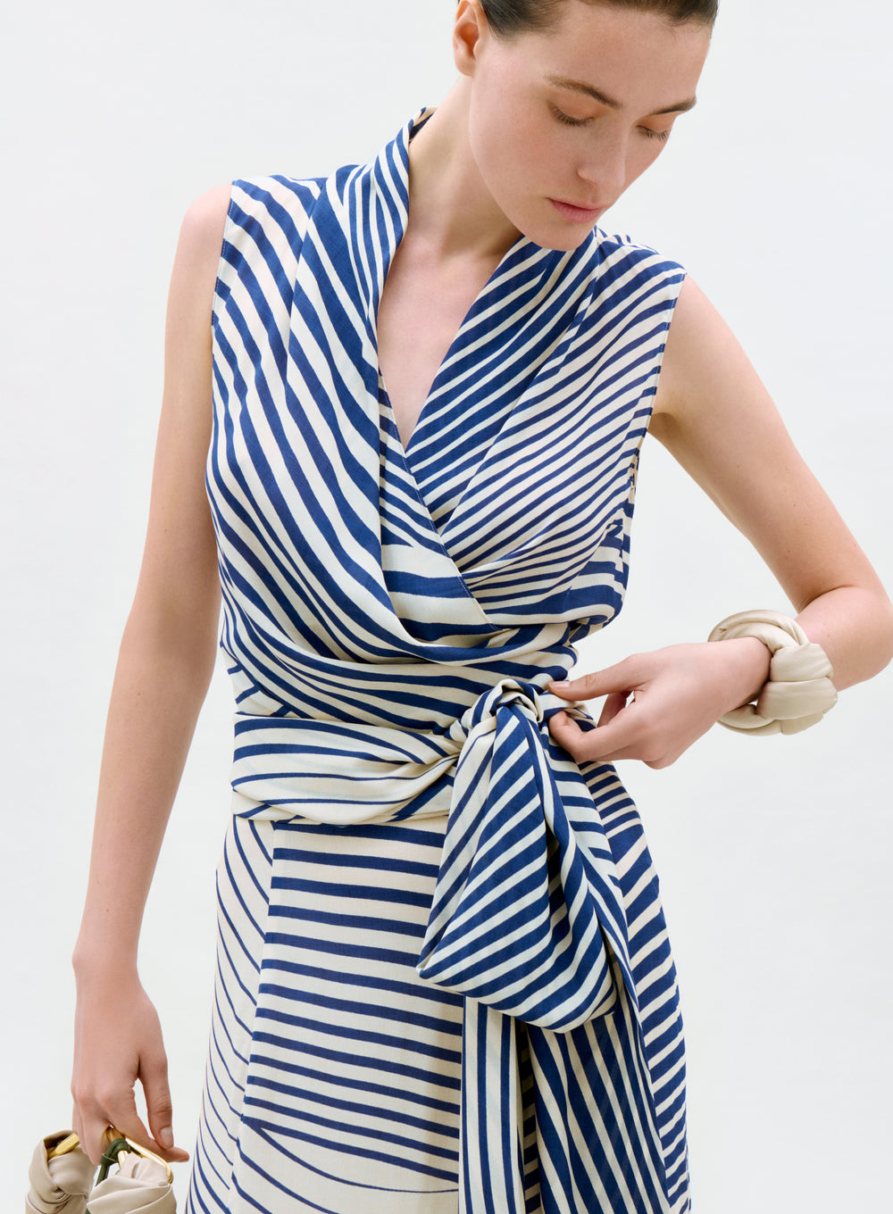 Woman wearing a blue and white striped dress against a plain background