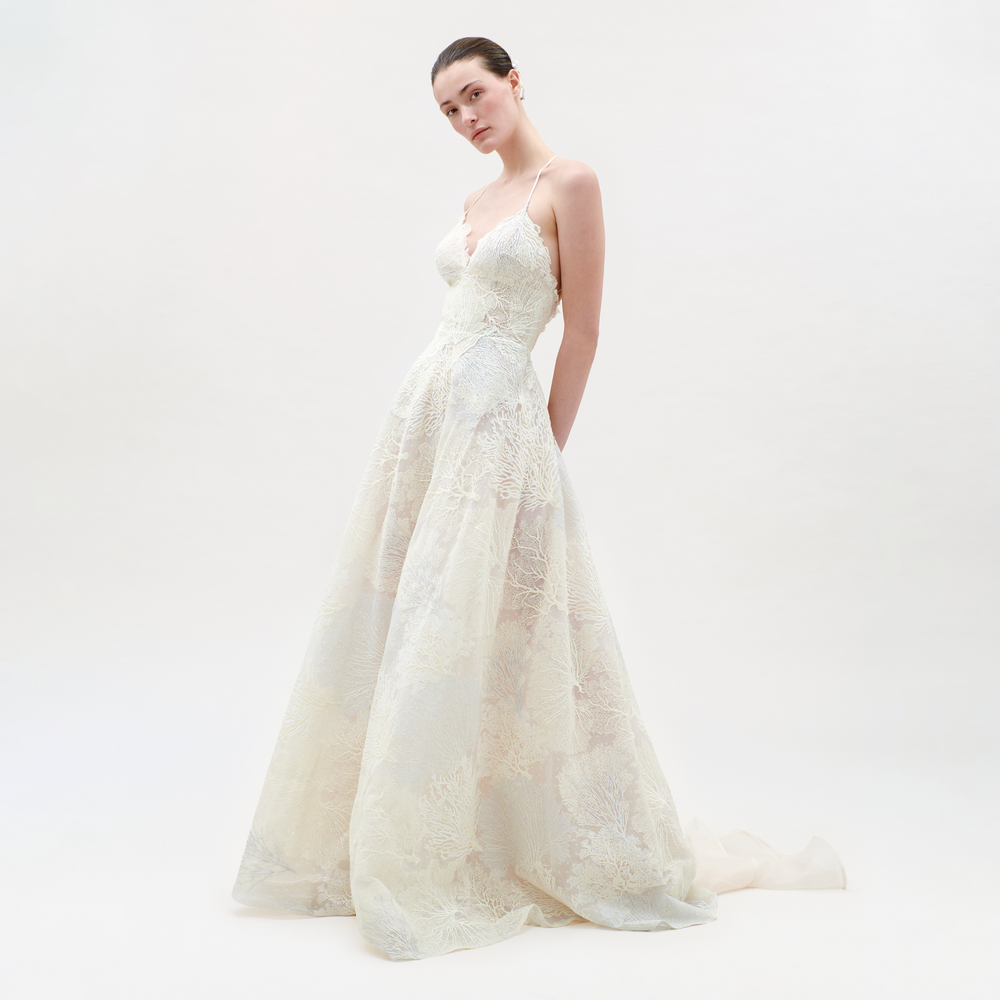 White lace wedding dress on a model against a white background