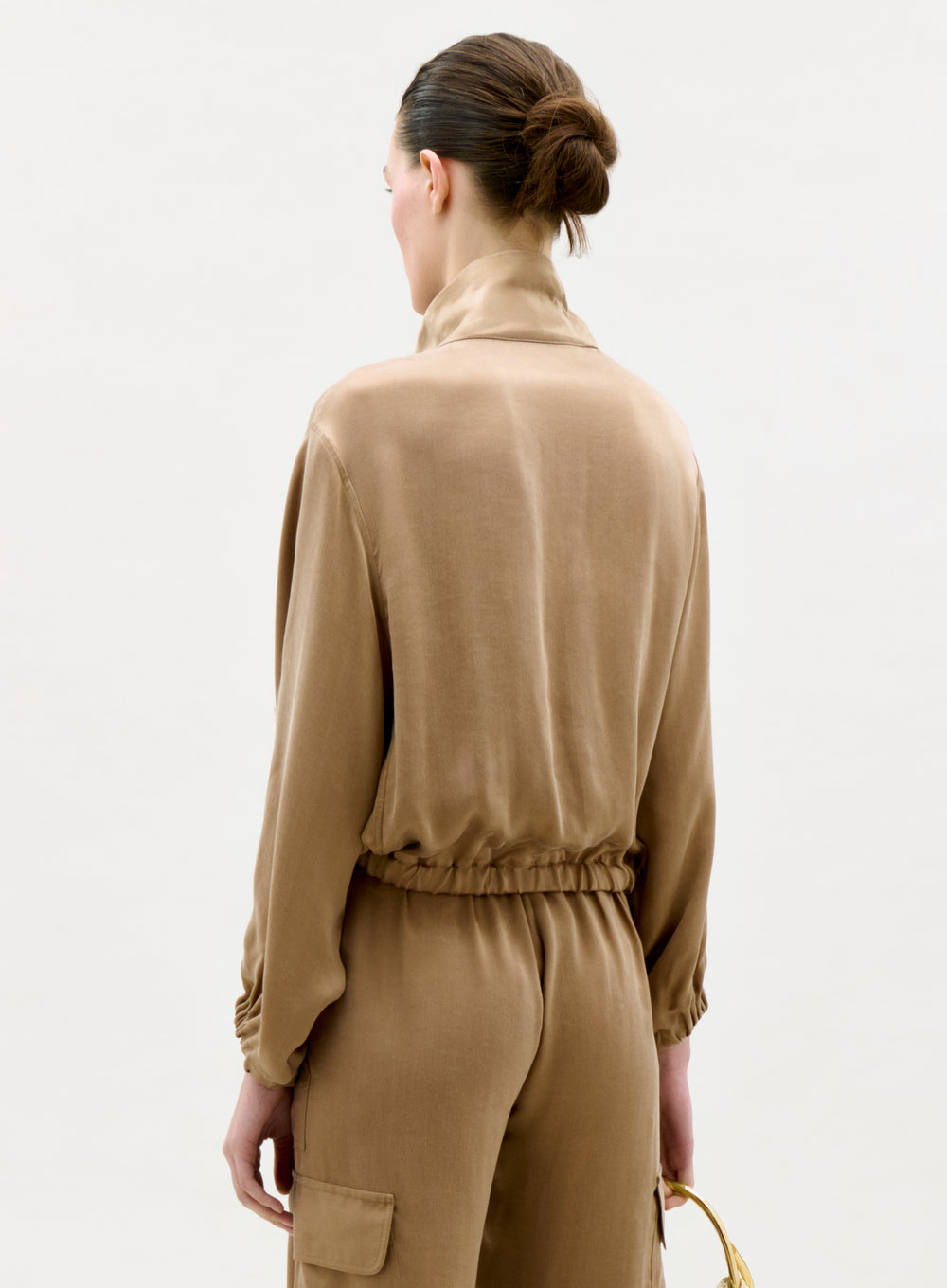Woman wearing a beige outfit on a white background