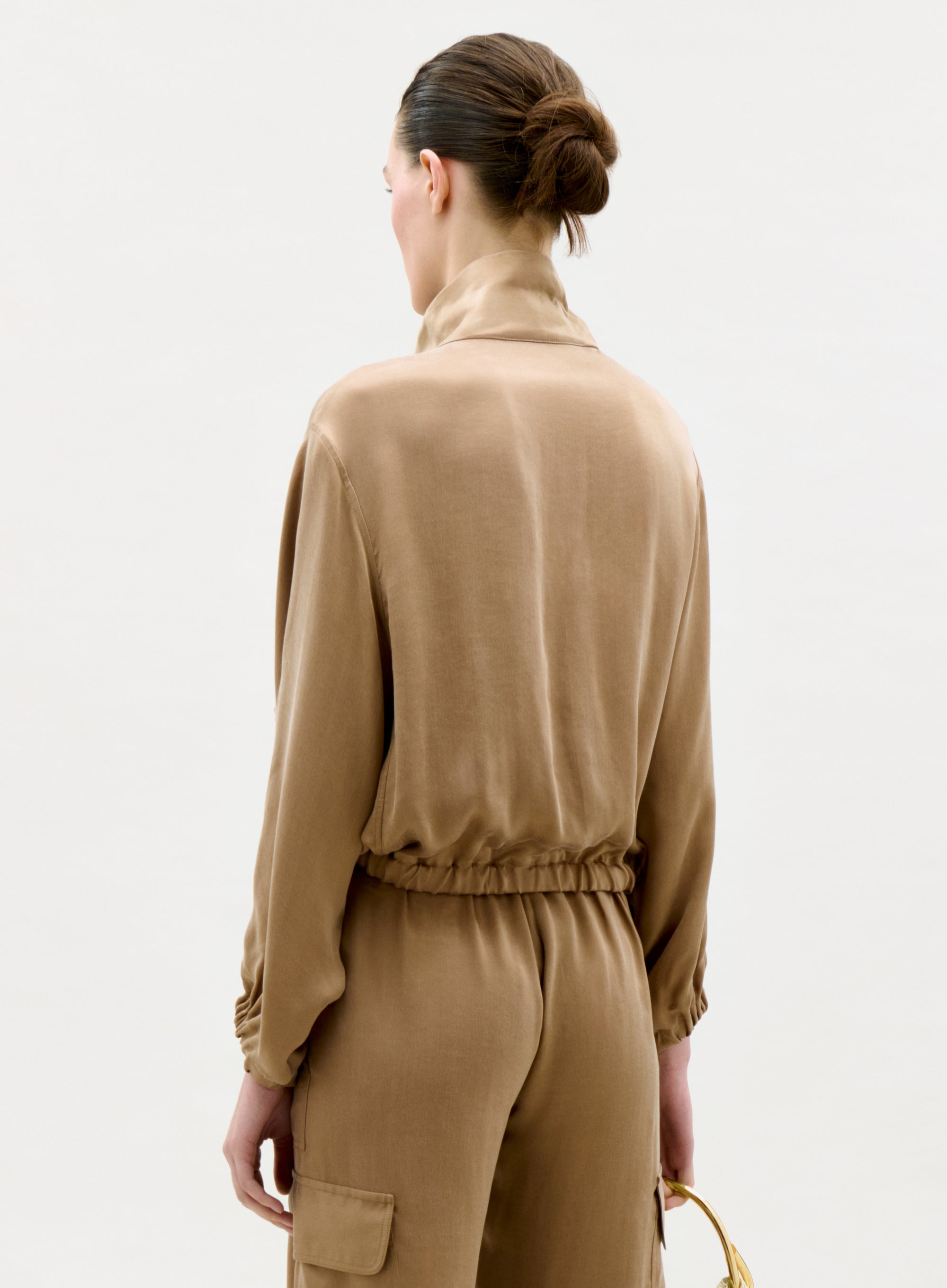 Woman wearing a beige outfit on a white background