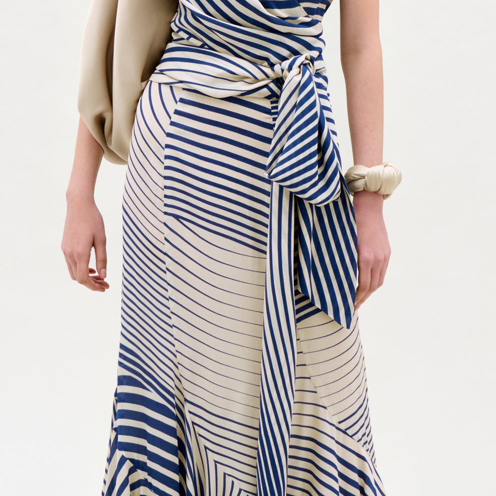 Woman wearing a blue and white striped dress with a plain background