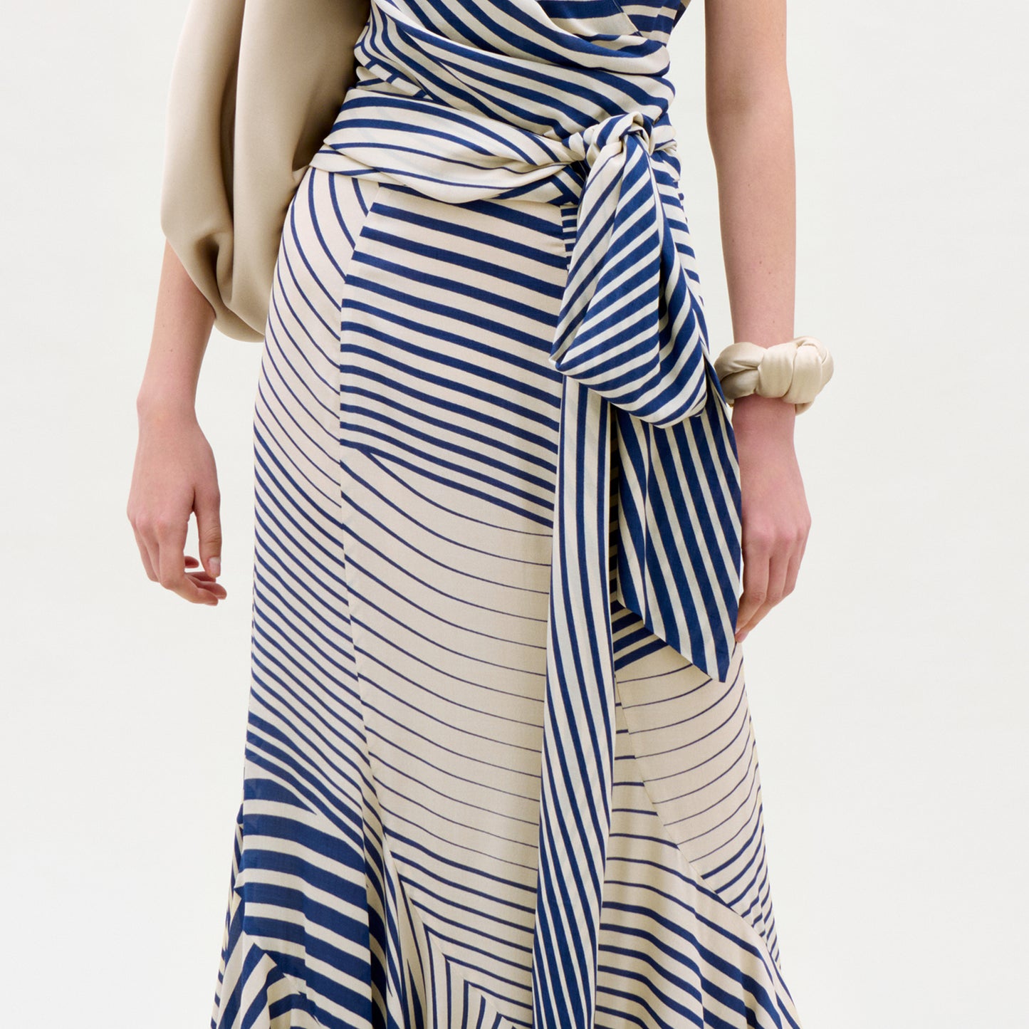 Woman wearing a blue and white striped dress with a plain background
