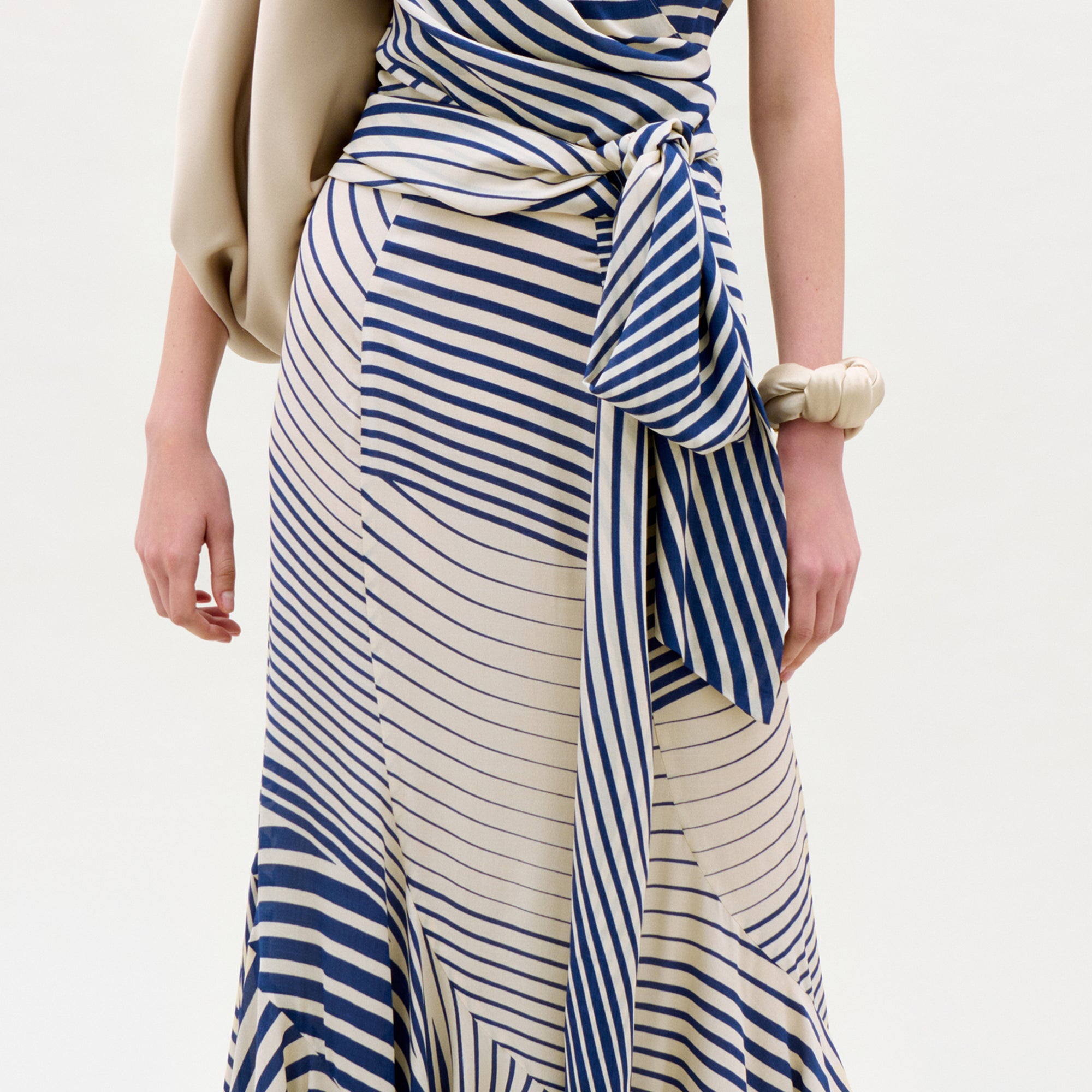 Woman wearing a blue and white striped dress with a plain background