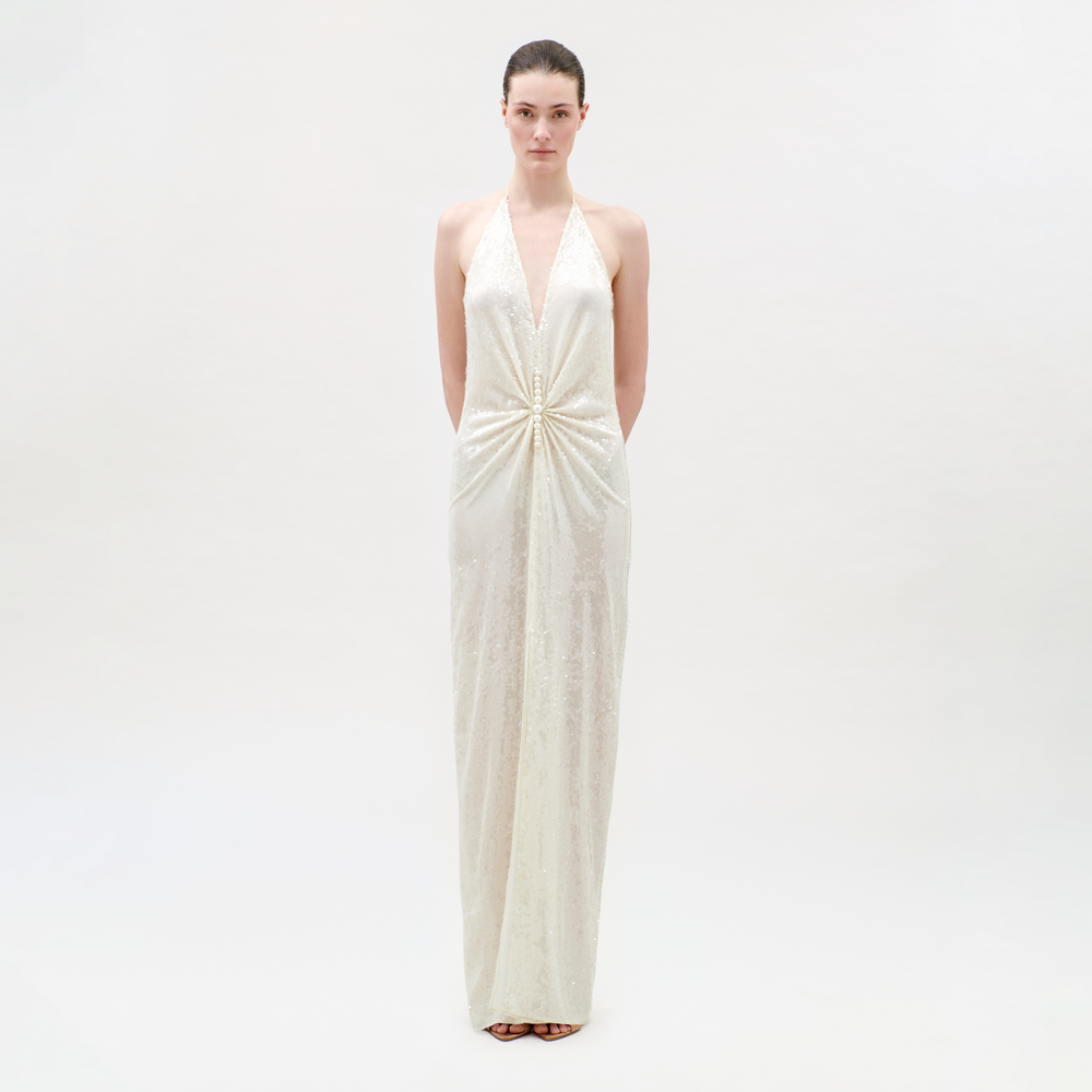 Woman wearing a white halter neck gown on a plain background