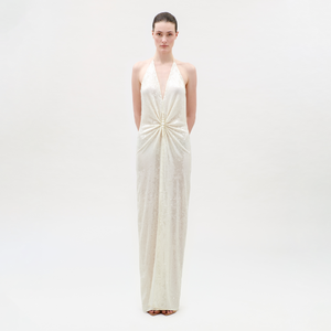Woman wearing a white halter neck gown on a plain background