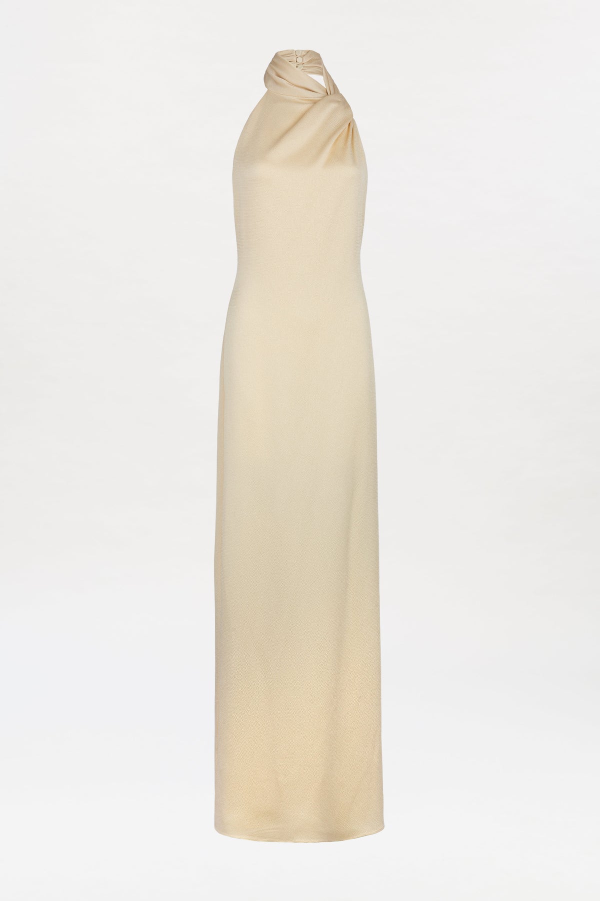 The Maica Dress is a sleeveless, floor-length beige halter gown crafted from smooth, flowing fabric and displayed against a plain white background.