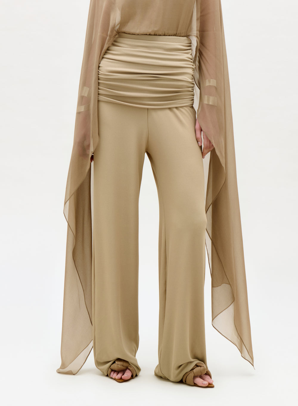 Beige outfit with a sheer overlay on a white background