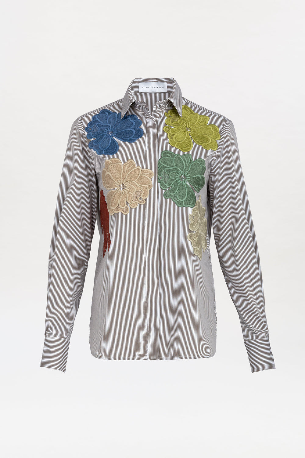 The Warda Shirt is a long-sleeve, black-and-white striped button-up featuring large colorful floral appliqués in blue, yellow, green, beige, and red across the upper front.