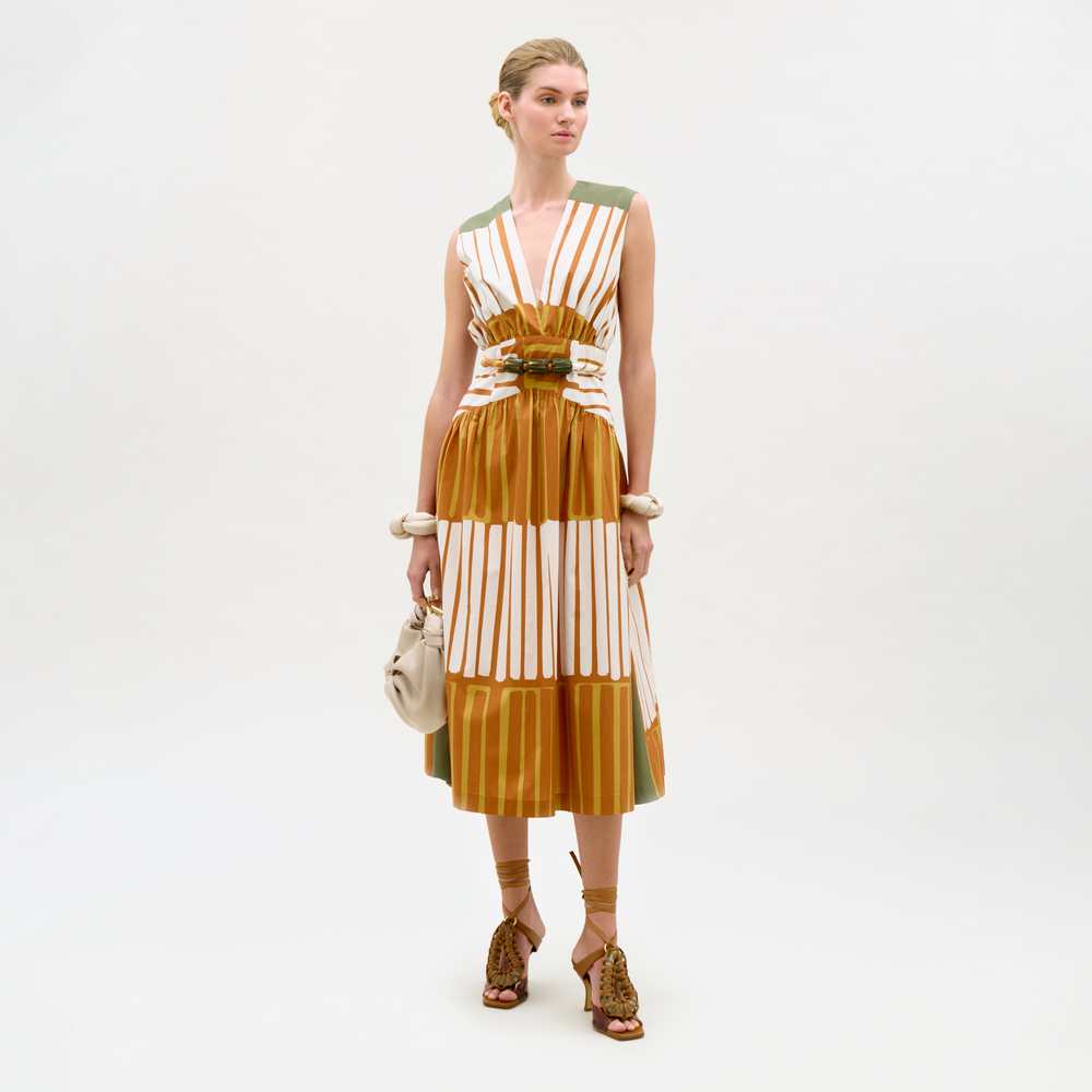 Woman wearing a striped dress with a belt on a white background