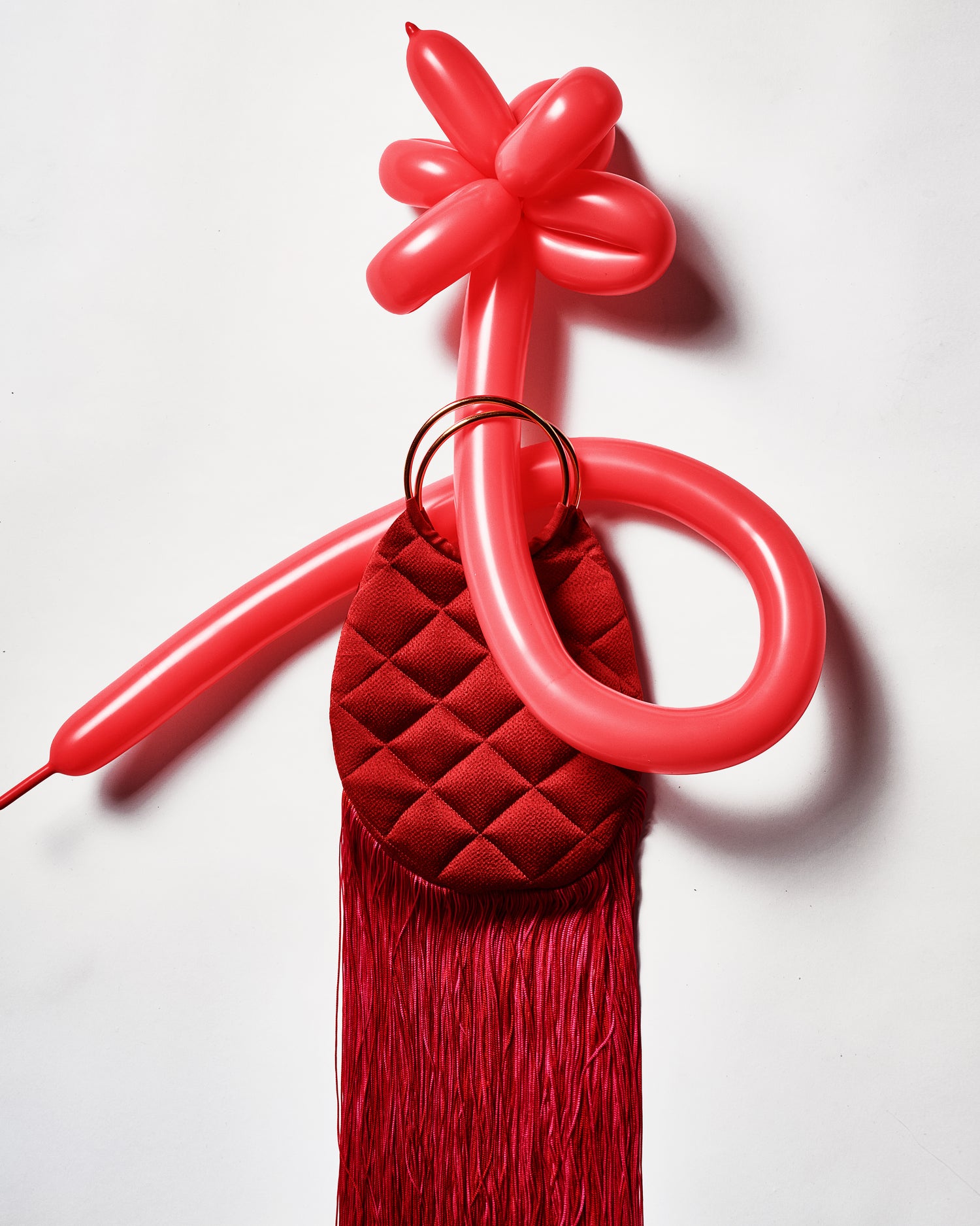 Red balloon arch with a tassel on a white background