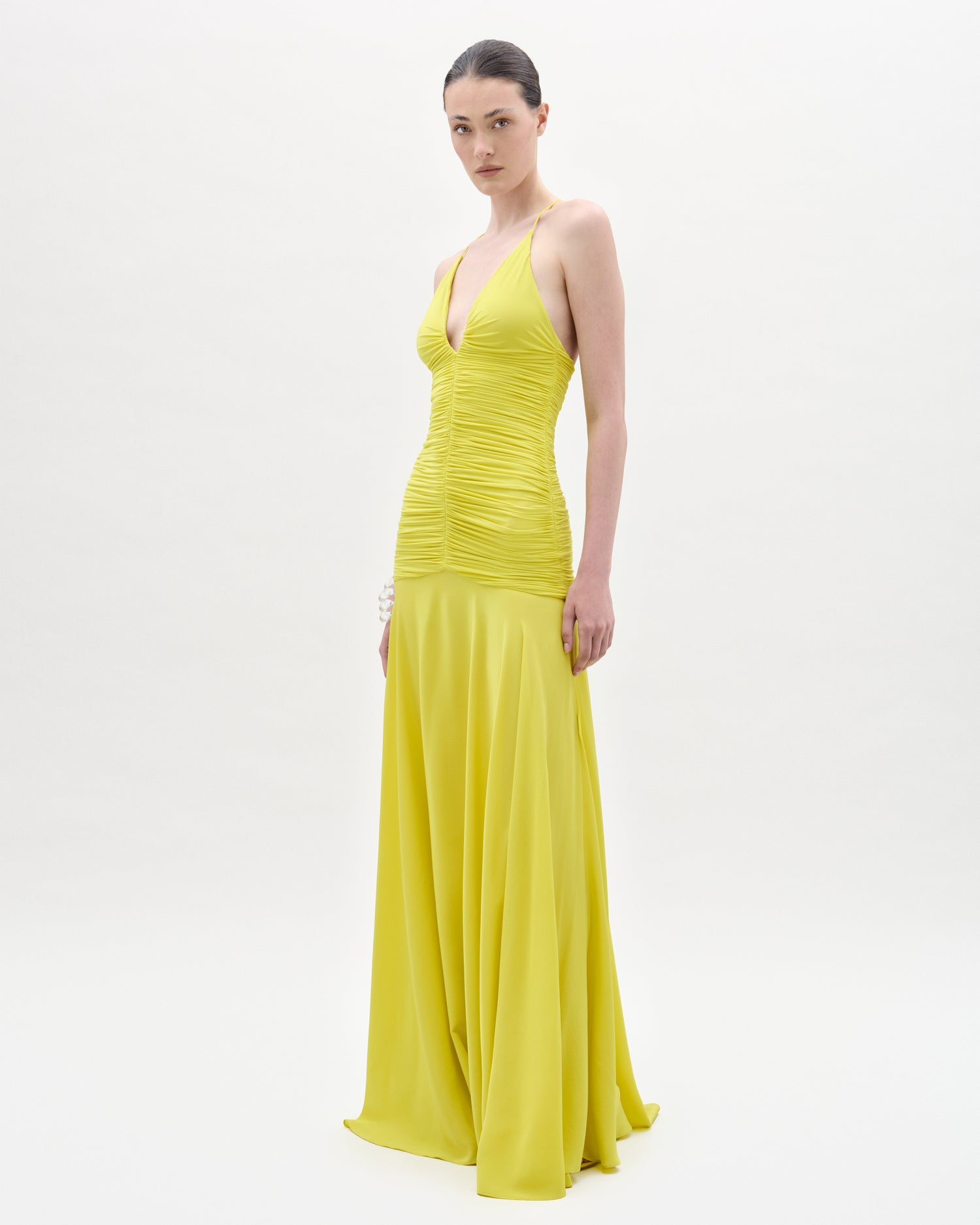 Woman wearing a yellow evening gown on a white background