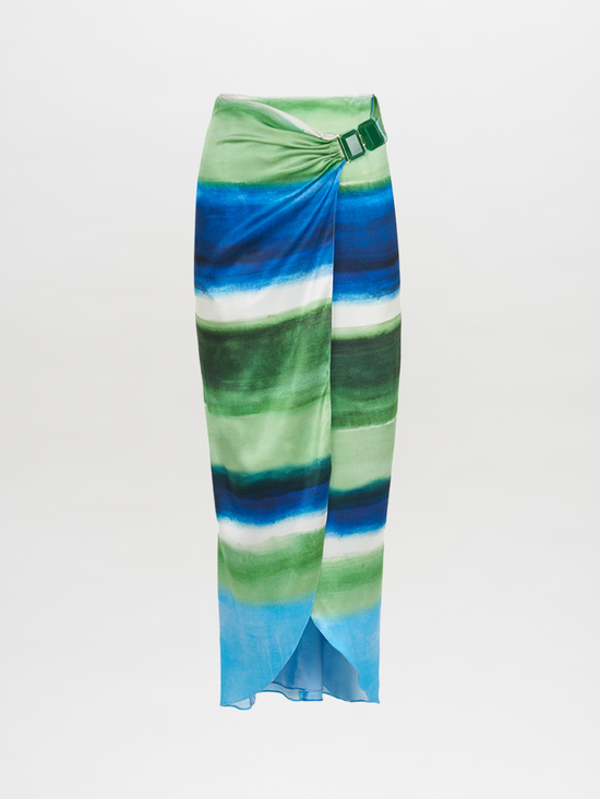 A long skirt with a tie-dye pattern in shades of blue and green, featuring a wrap design and a belt buckle detail at the waist. The Adrianne Skirt Washed Emerald Blue is final sale and not eligible for return.