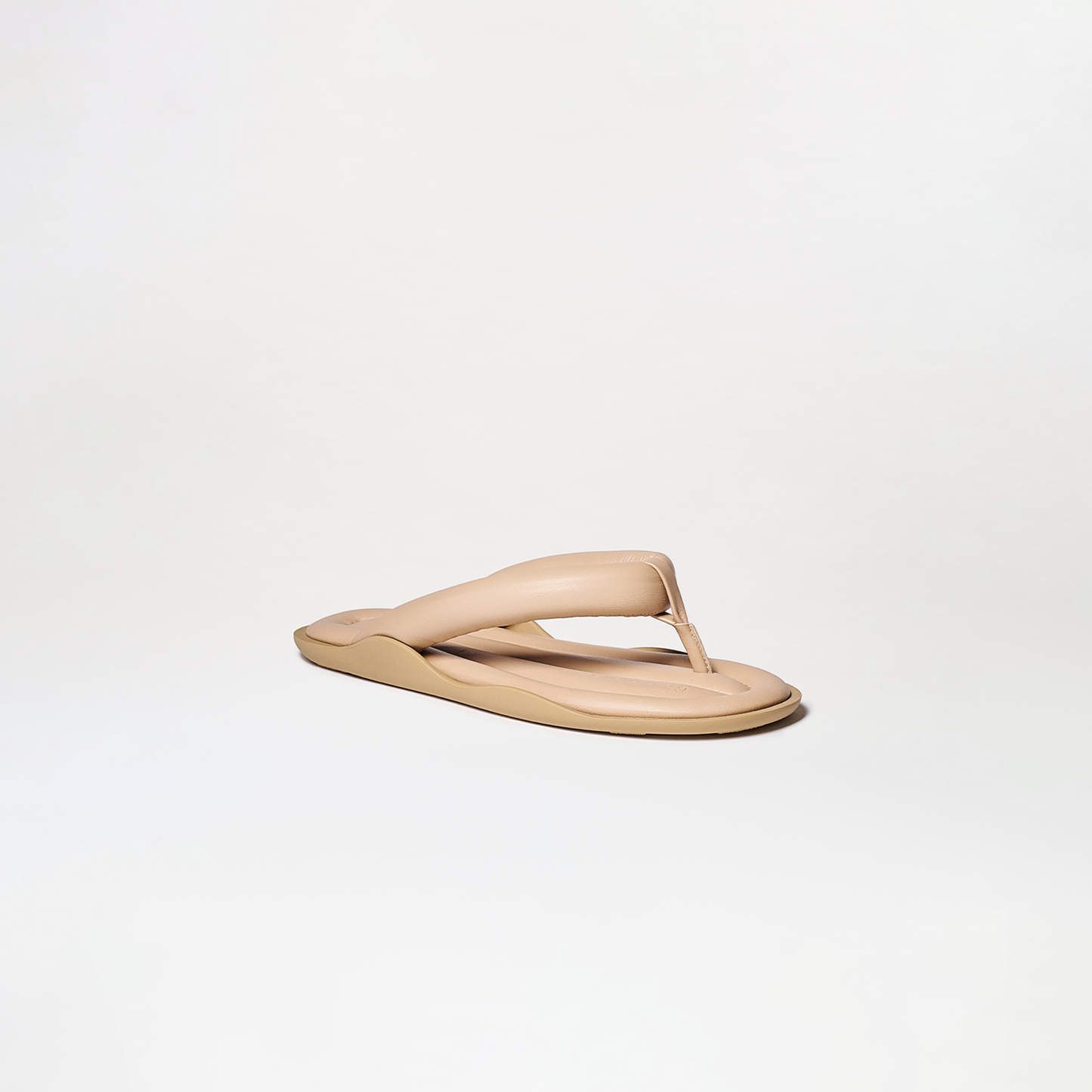 The Harper Sandals feature a single beige flip-flop with thick, cushioned straps and a slightly elevated sole, displayed against a plain white background.