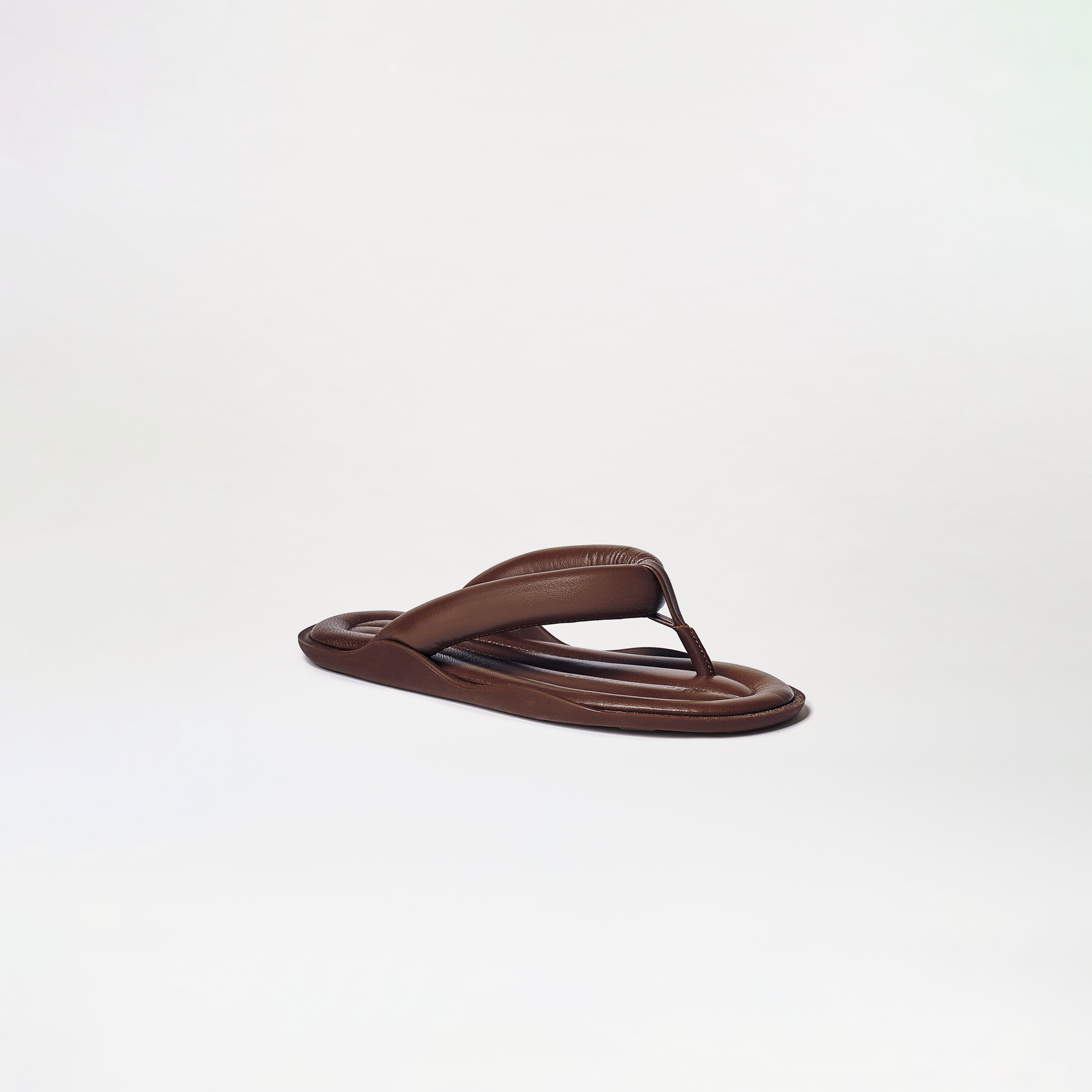 The Harper Sandals feature a single brown flip-flop with a padded thong strap and cushioned sole, showcased against a plain, light background.
