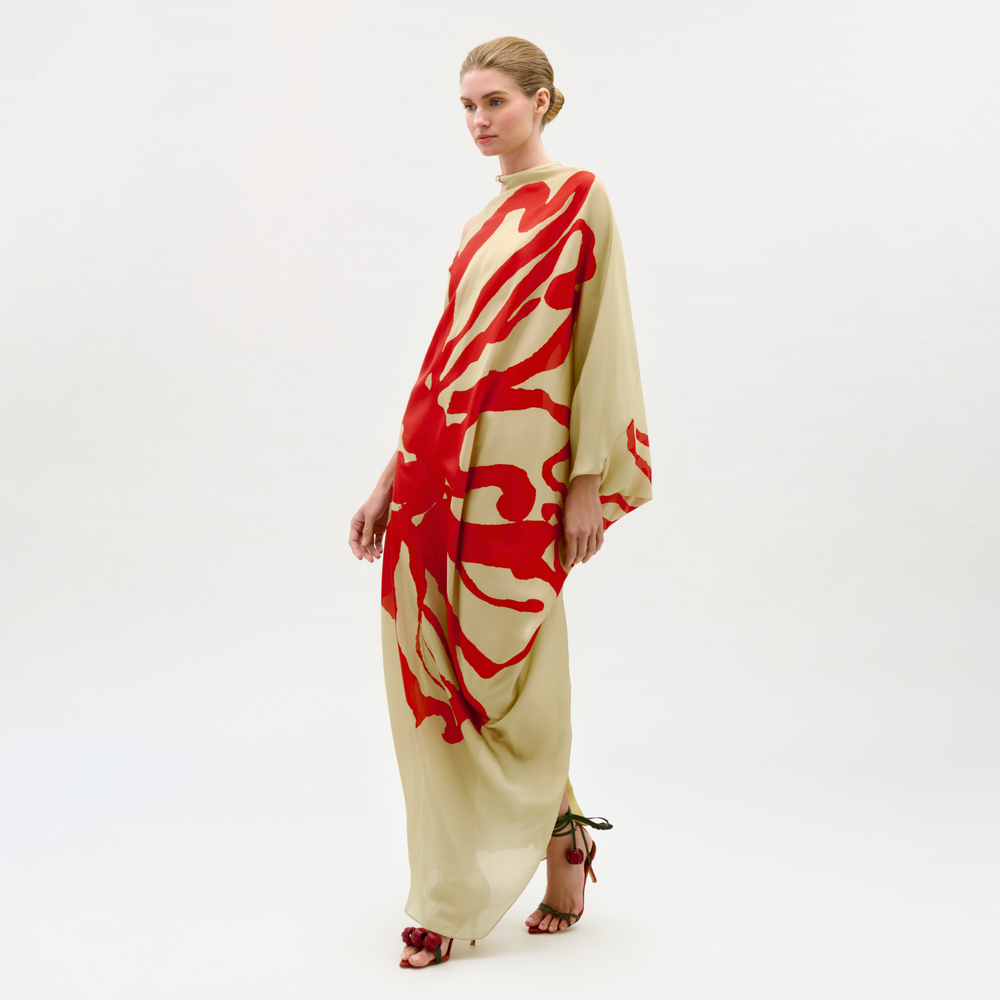 Woman wearing a beige and red patterned dress on a white background