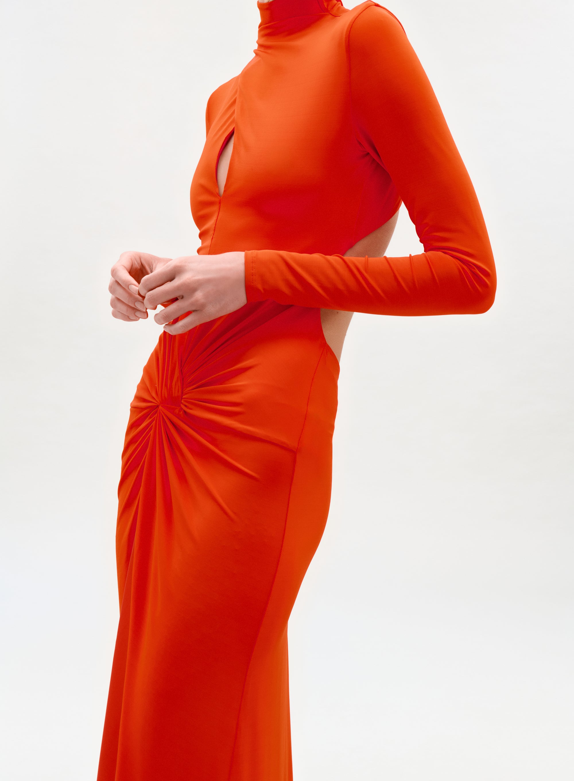 Orange evening gown with long sleeves and cut-out design on a white background