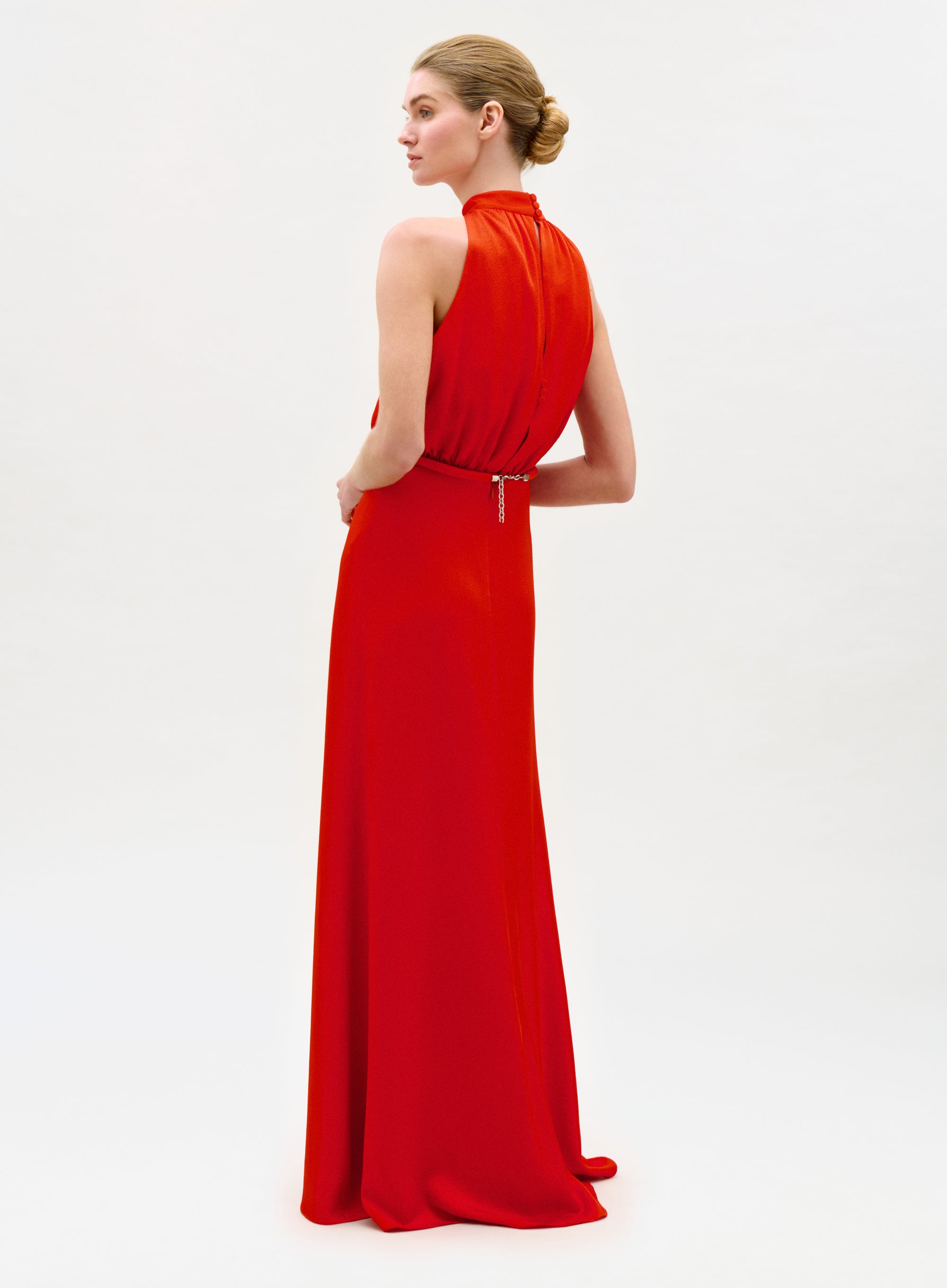 Woman wearing a red evening gown on a white background
