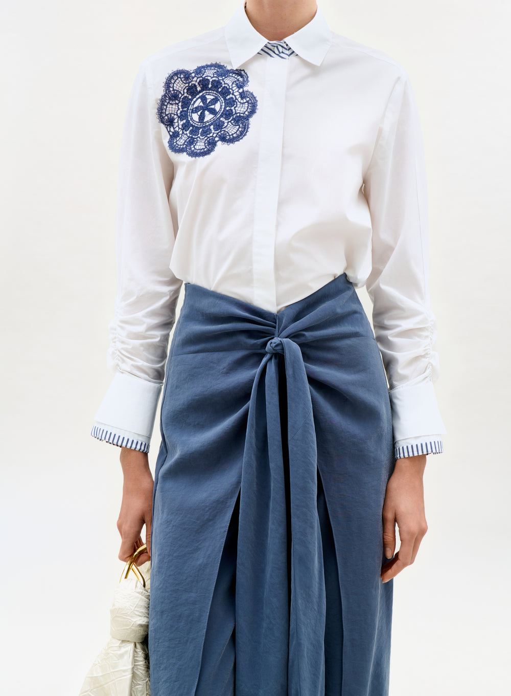 White shirt with blue embroidery and blue skirt on a white background