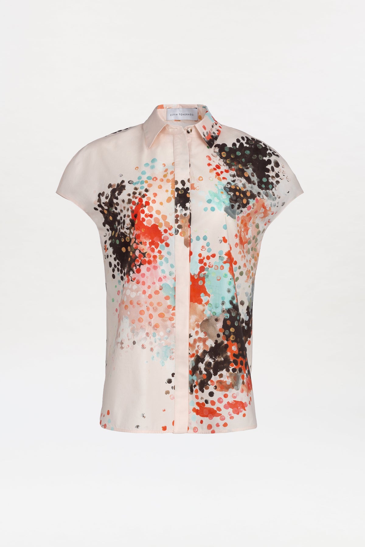 Maribel Shirt: A short-sleeved blouse featuring a structured collar and slightly flared silhouette, designed with an eye-catching abstract dotted pattern in black, red, turquoise, and brown on a light background. Visible front buttons complete the look.