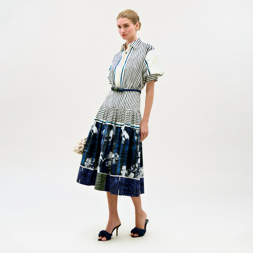 Woman wearing a striped shirt and floral skirt on a white background