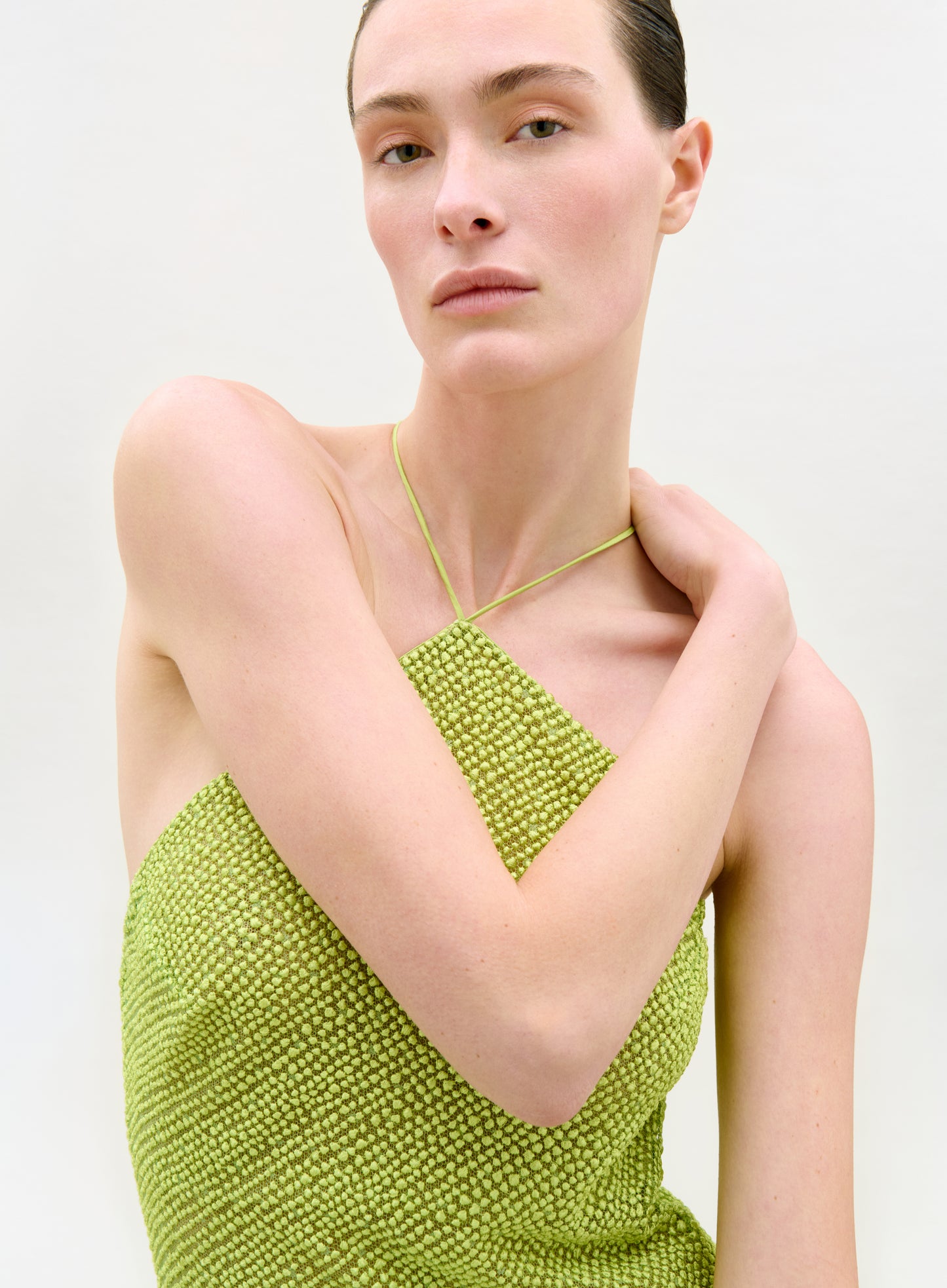 Woman wearing a green beaded dress against a white background