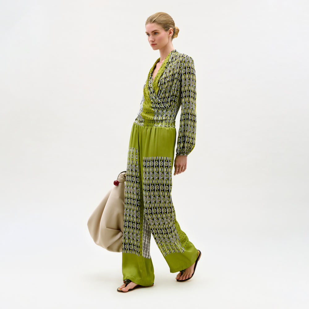 Woman wearing a green and patterned outfit on a white background