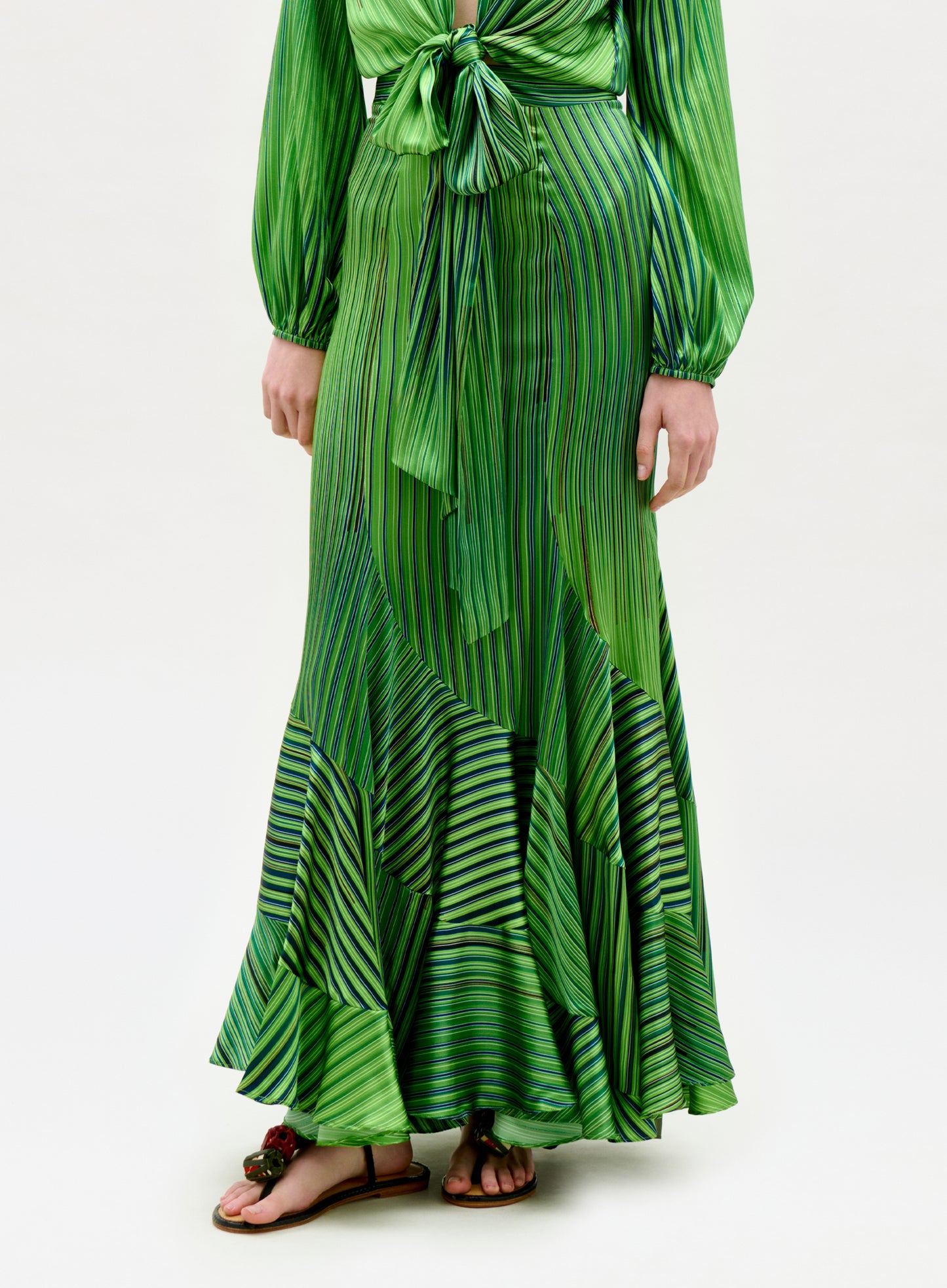 Green patterned dress worn by a person on a white background