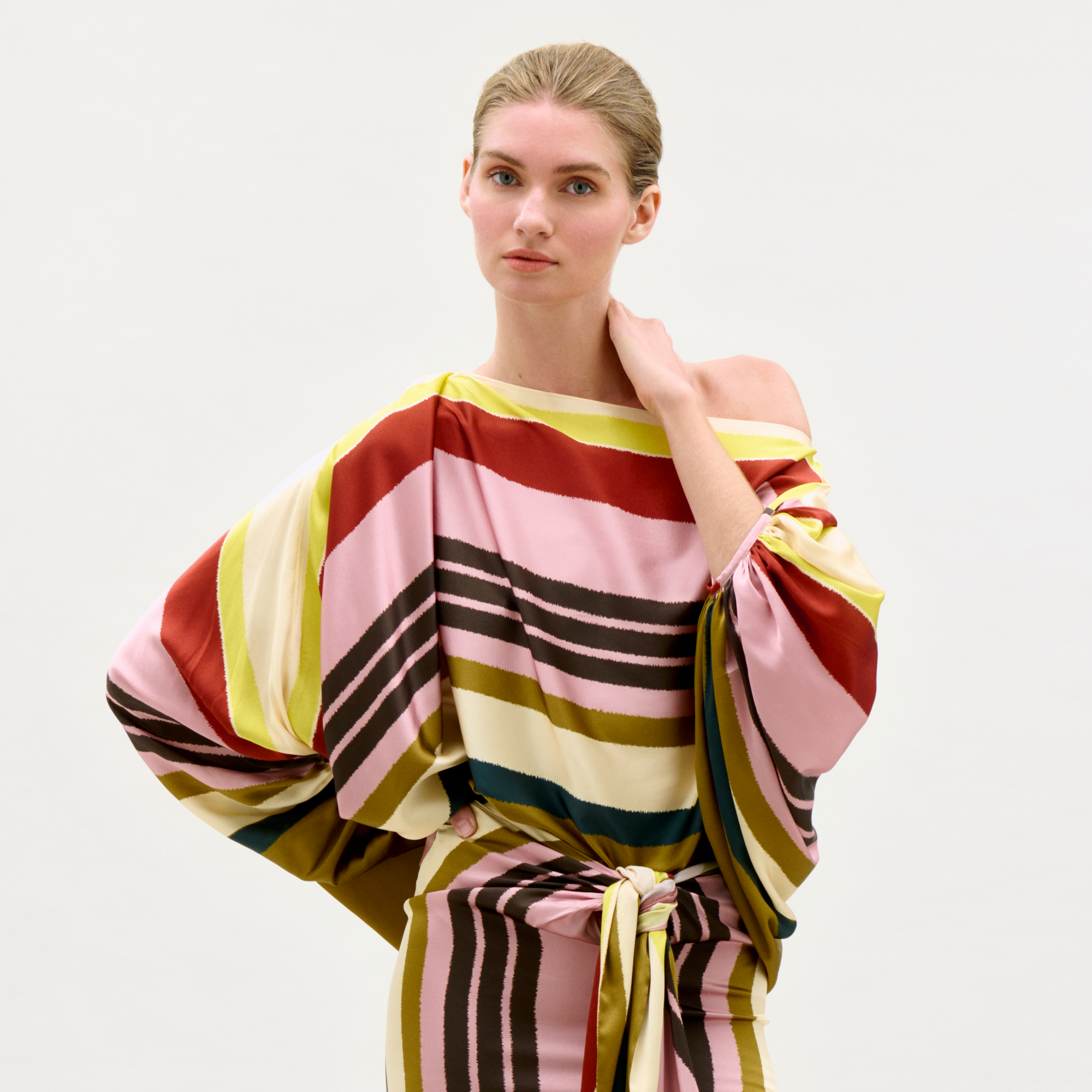 Woman wearing a colorful striped outfit on a white background