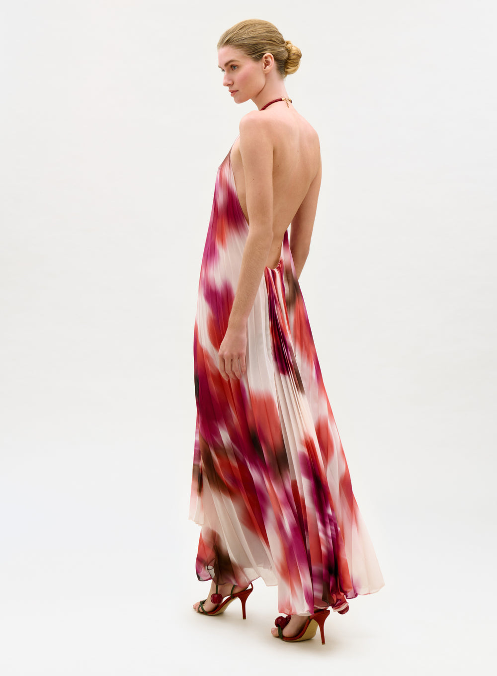 Woman wearing a colorful halter neck dress on a white background