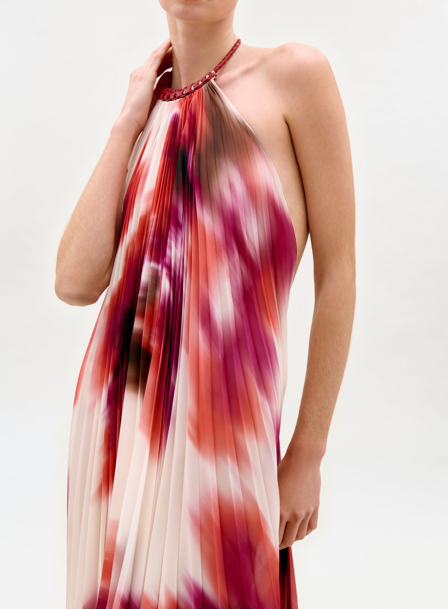 Woman wearing a colorful halter neck dress on a white background