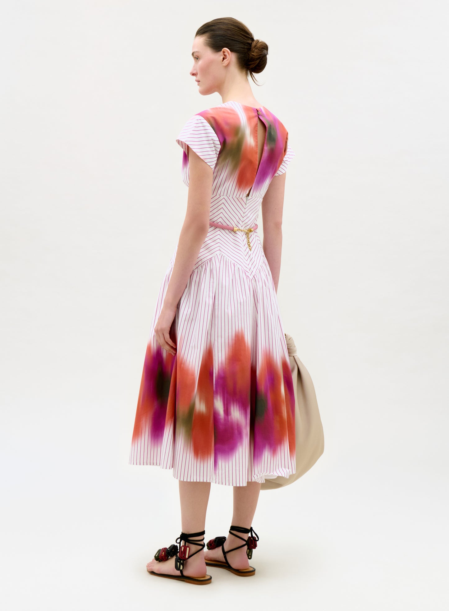 Woman wearing a colorful dress with abstract patterns on a white background