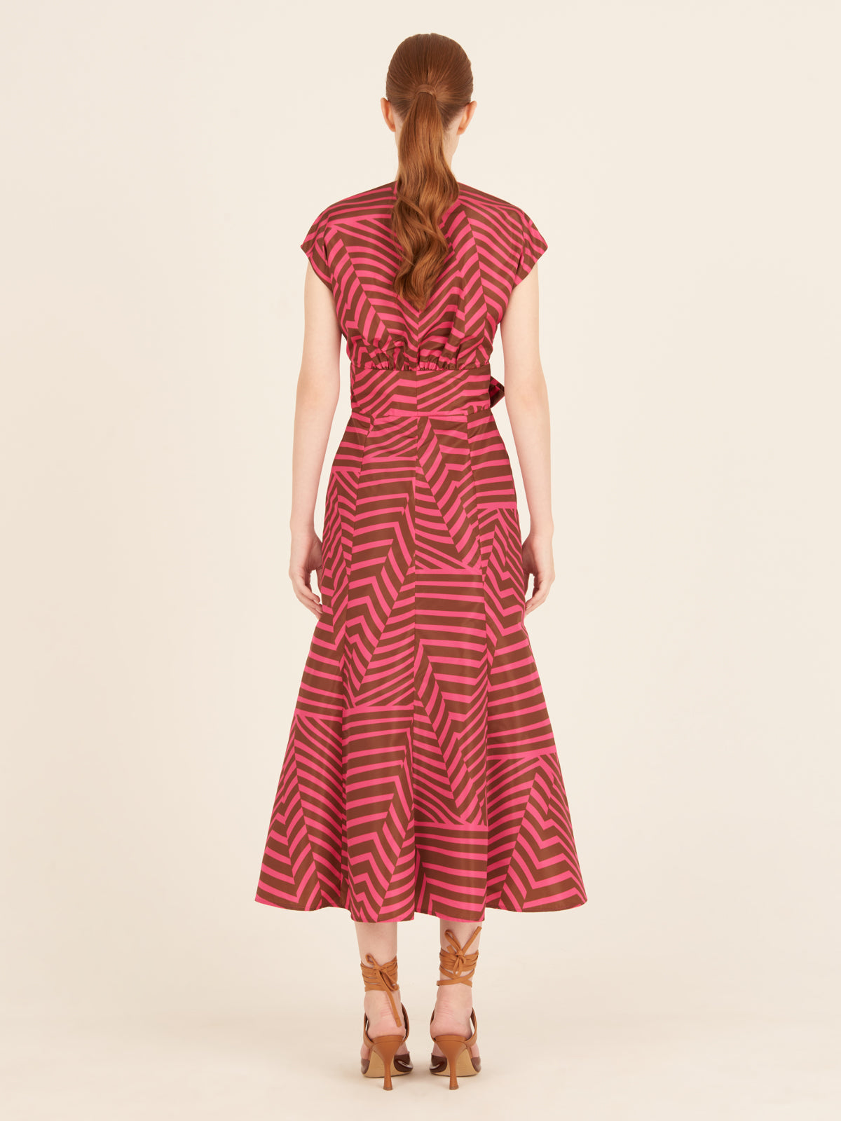 A feminine Toledo Dress Fuchsia Cacao with a bow, perfect for any occasion.