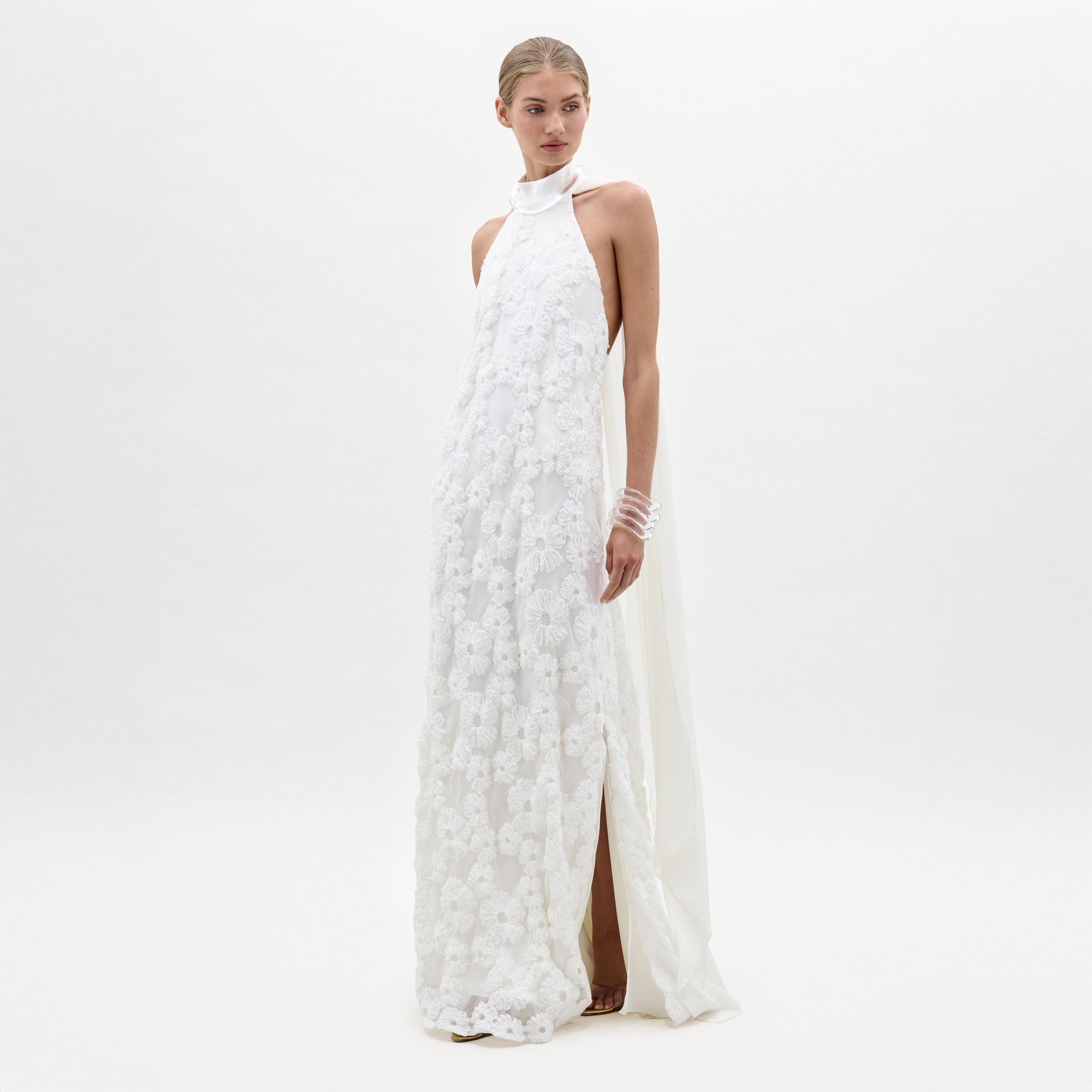 Woman wearing a white floral dress on a plain background