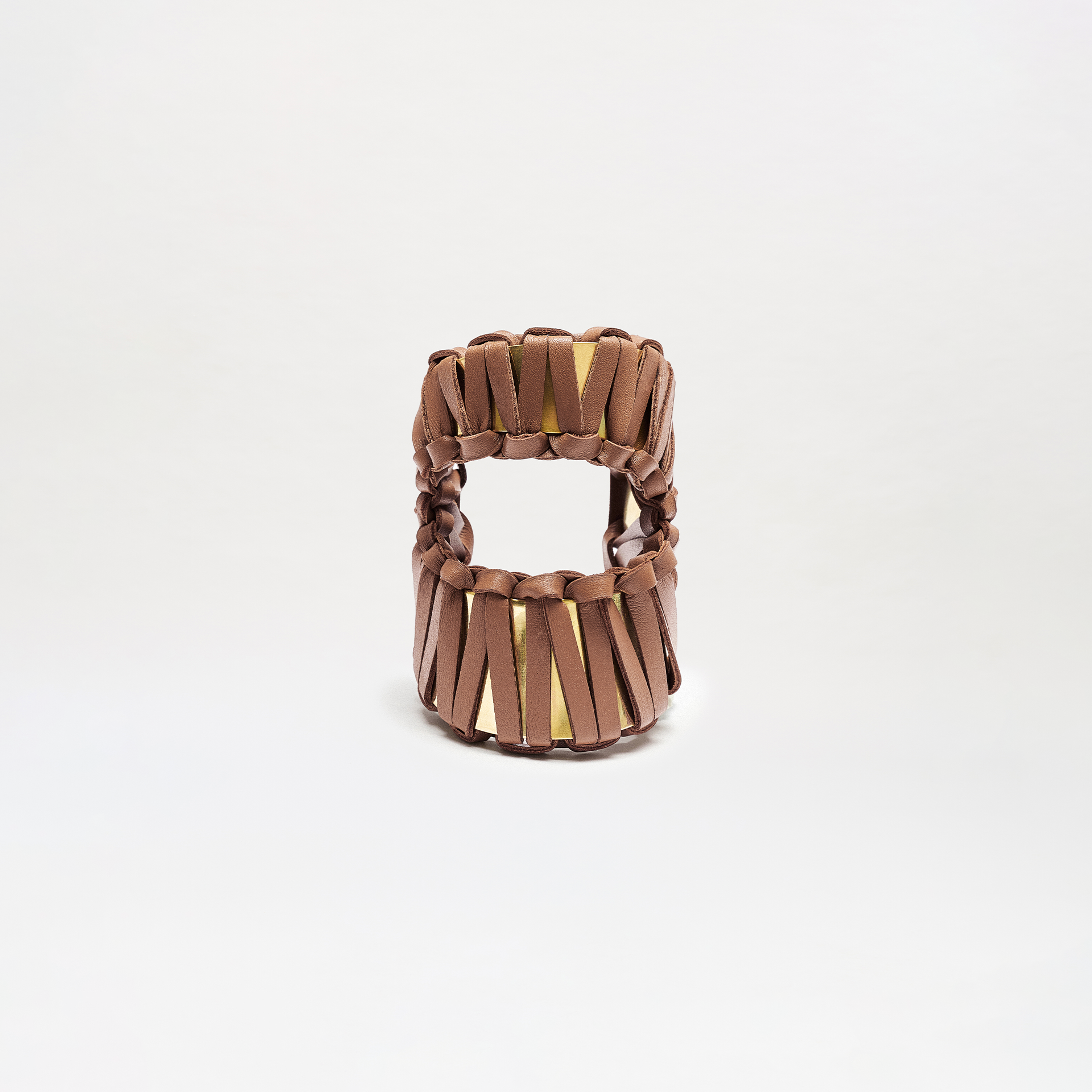 The Majel Cuff is a brown woven sandal featuring thick horizontal leather straps and a gold insole, shown from the front on a plain white background.